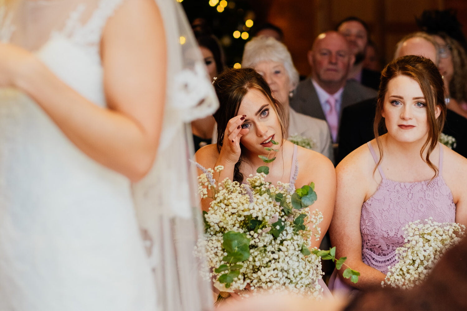 bridesmaid wipes away tears during ceremony
