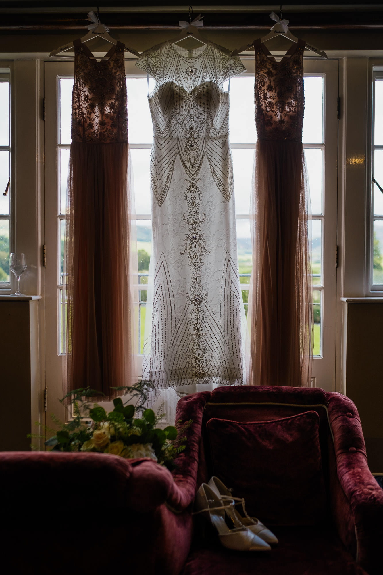 Wedding and bridesmaid dresses hung with flowers and shoes