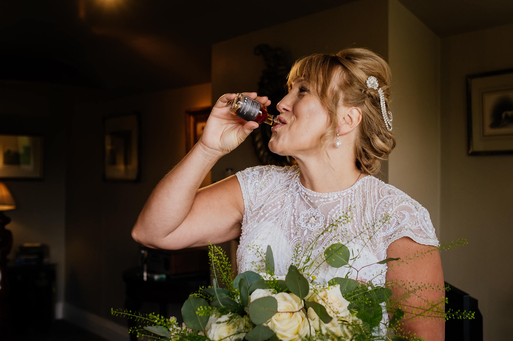 Bride taking a shot of whiskey