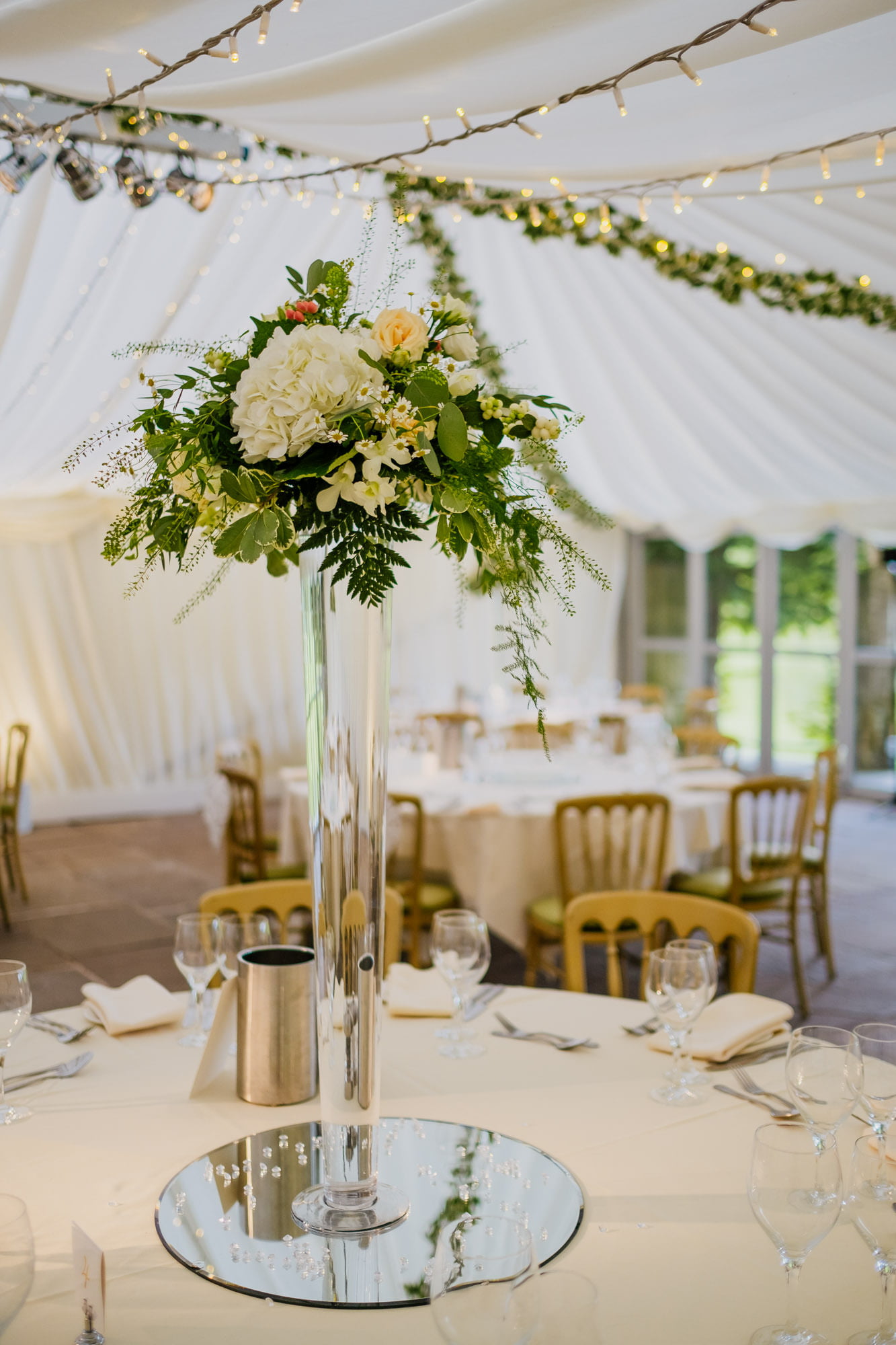 Tall glass vase centrepiece with flowers