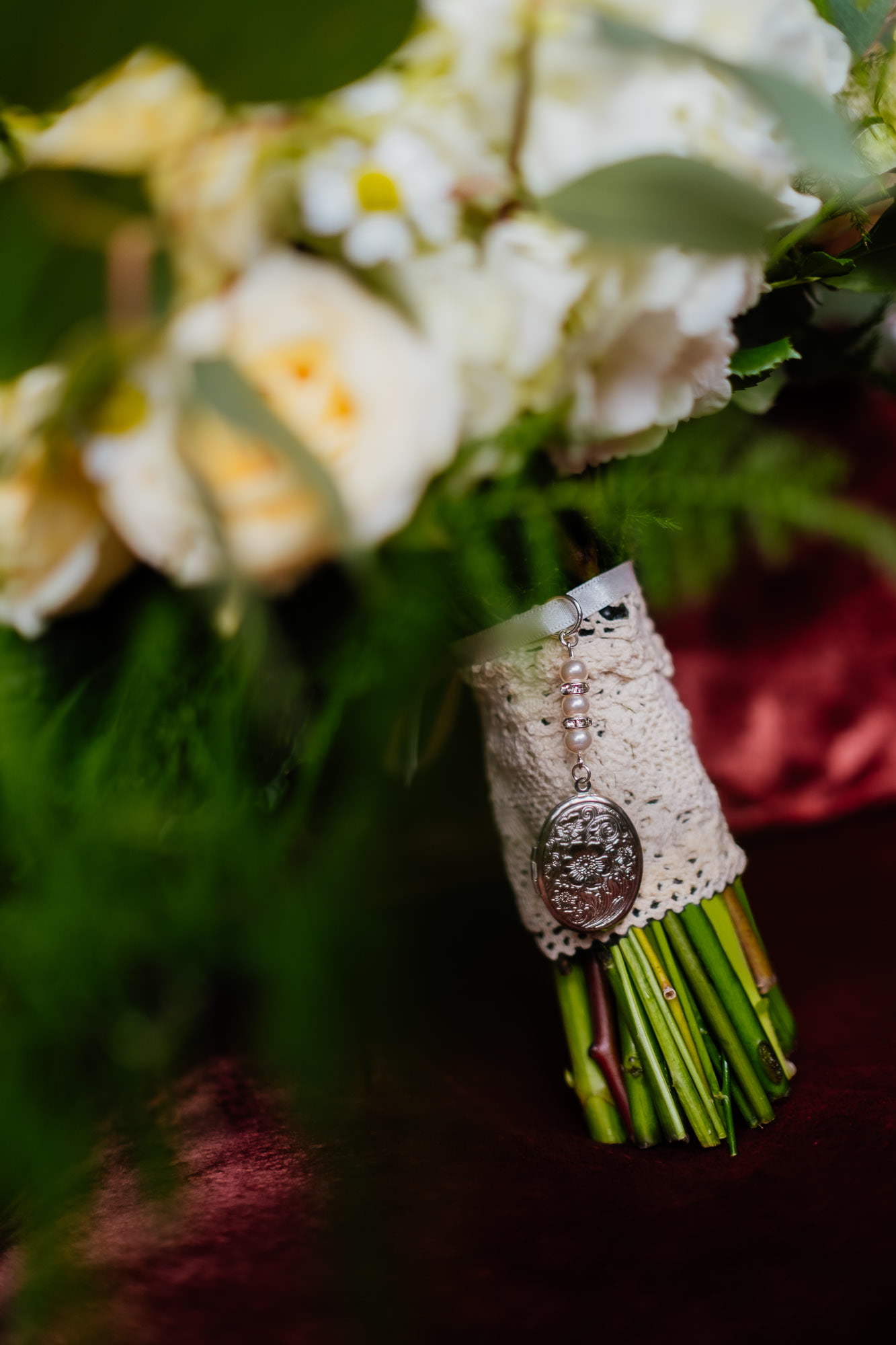 Silver locket charm on wedding bouquet