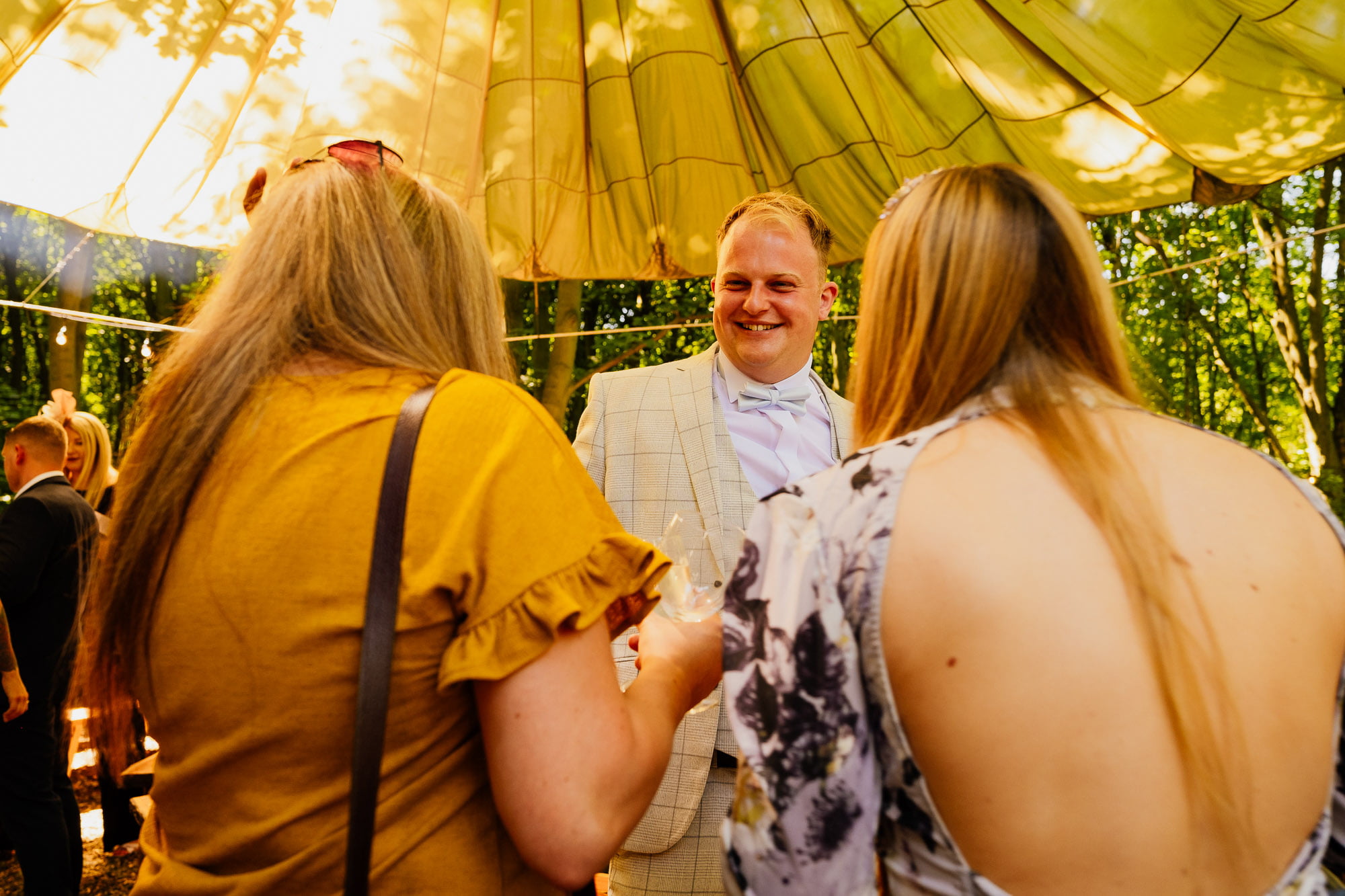 groom smiling between two wedding guests