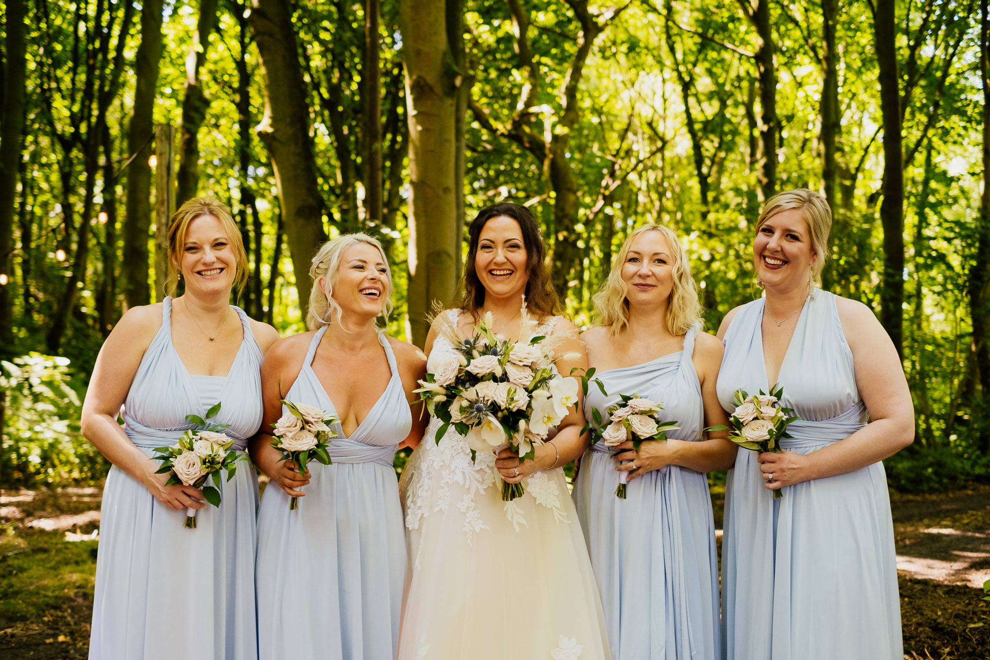 bride and bridemaids in woodland setting
