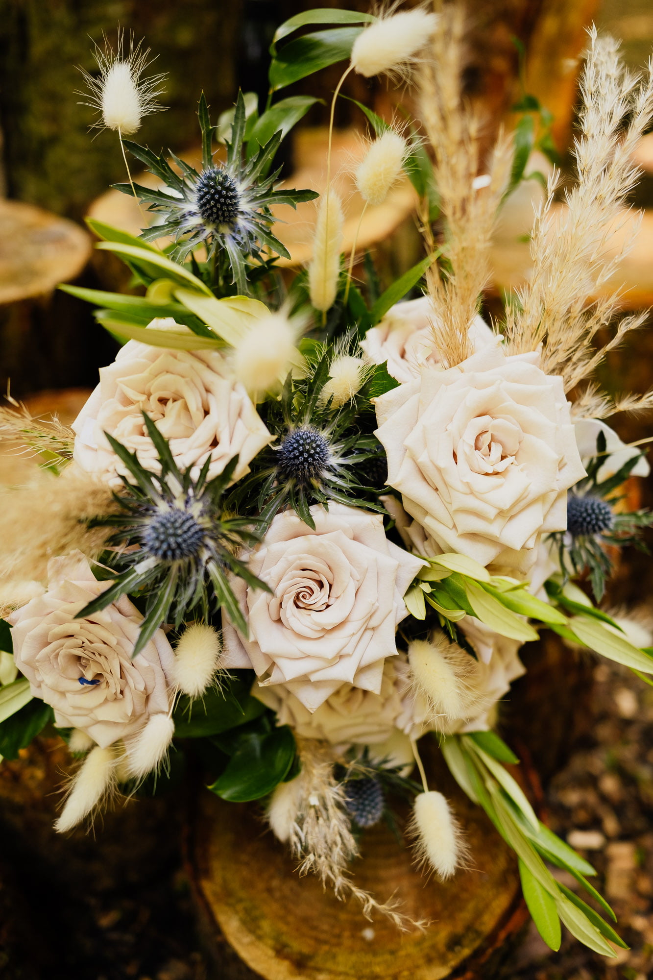 wedding bouquet with pale roses and thistles