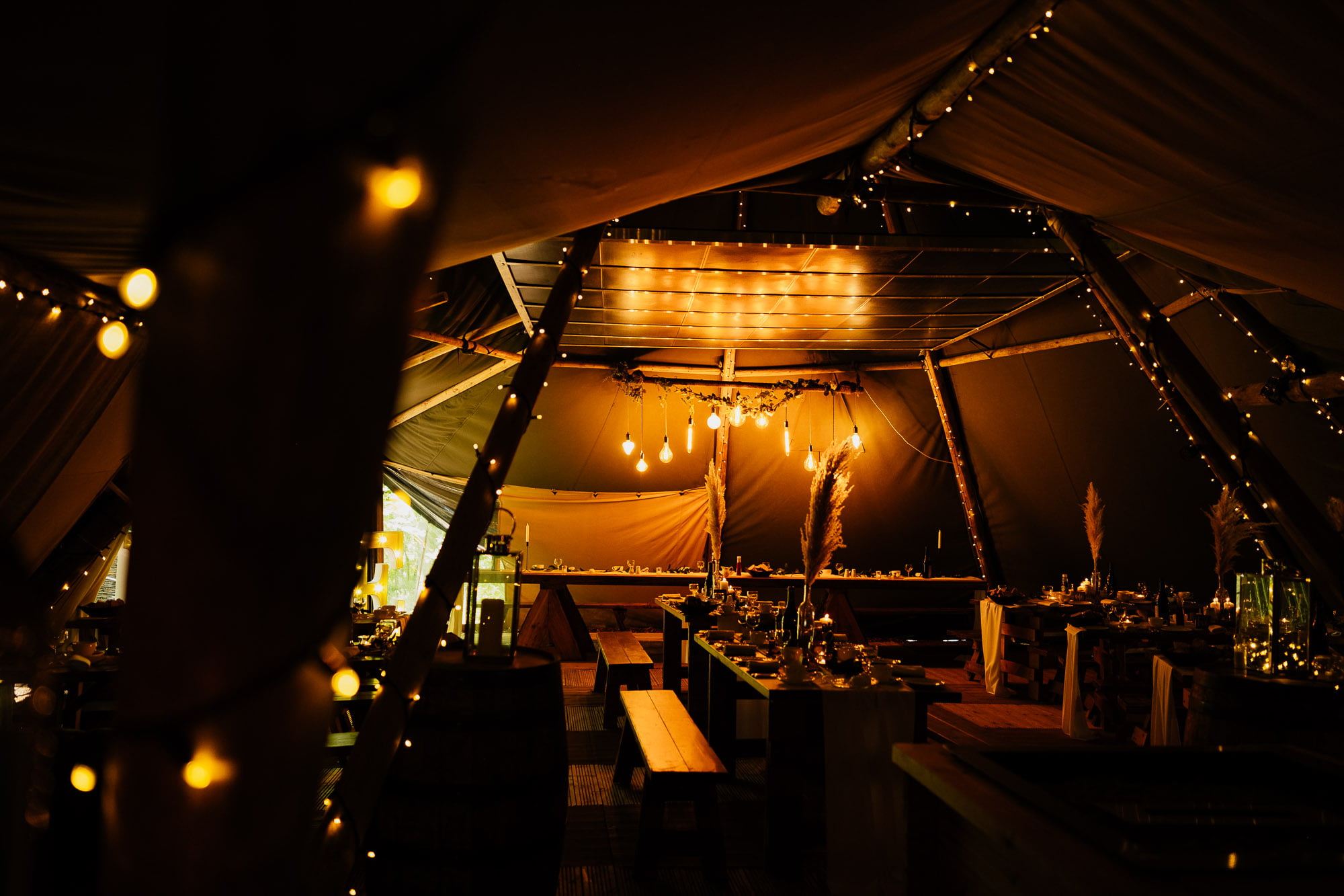 Warm cosy tipi at cockley wood weddings lit with fairy lights