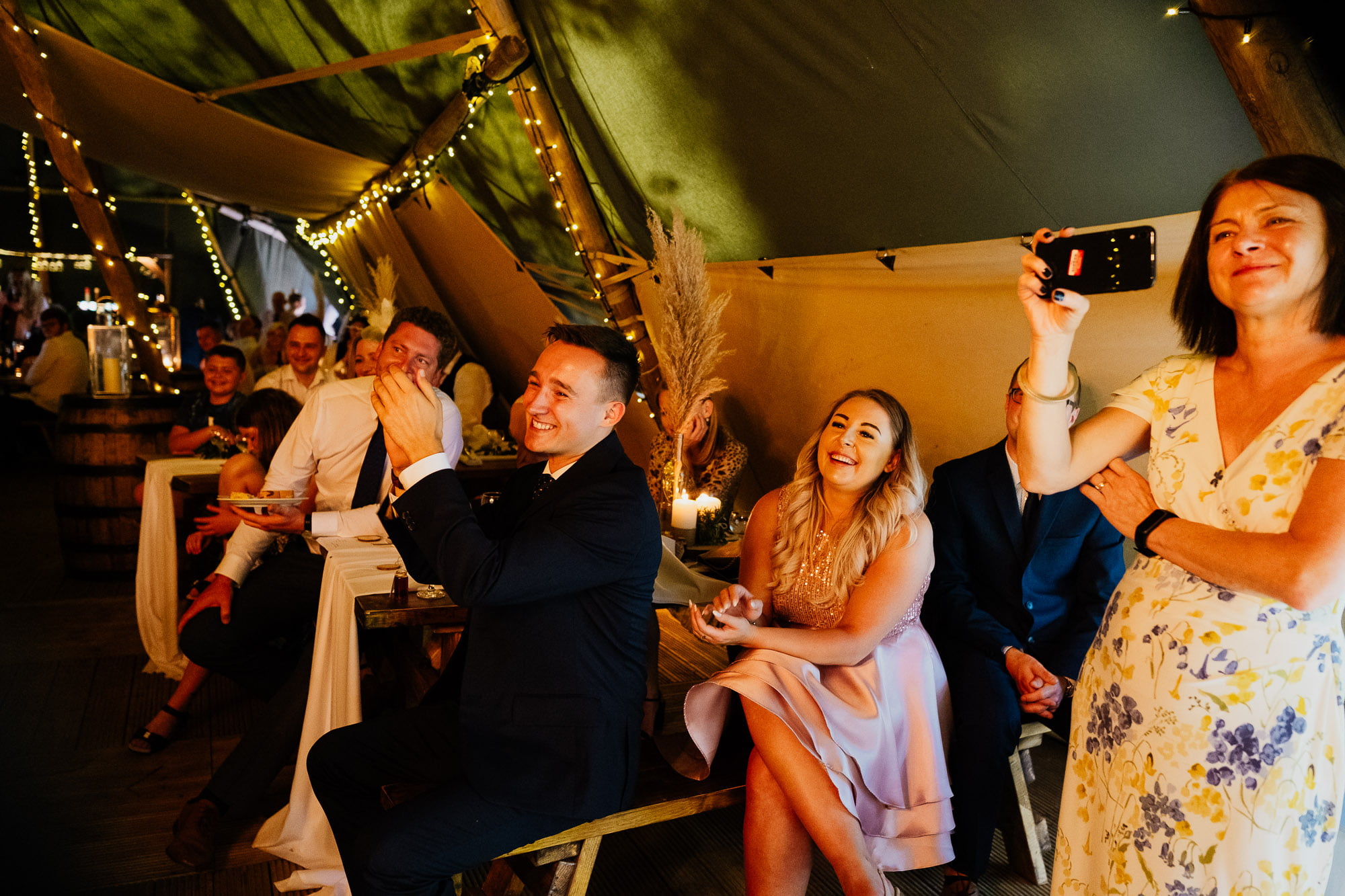 Guests reacting to speech from best men at wedding