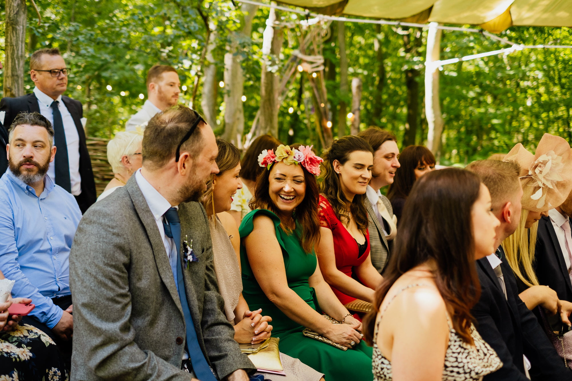 wedding guests in flower crown laughing during ceremony