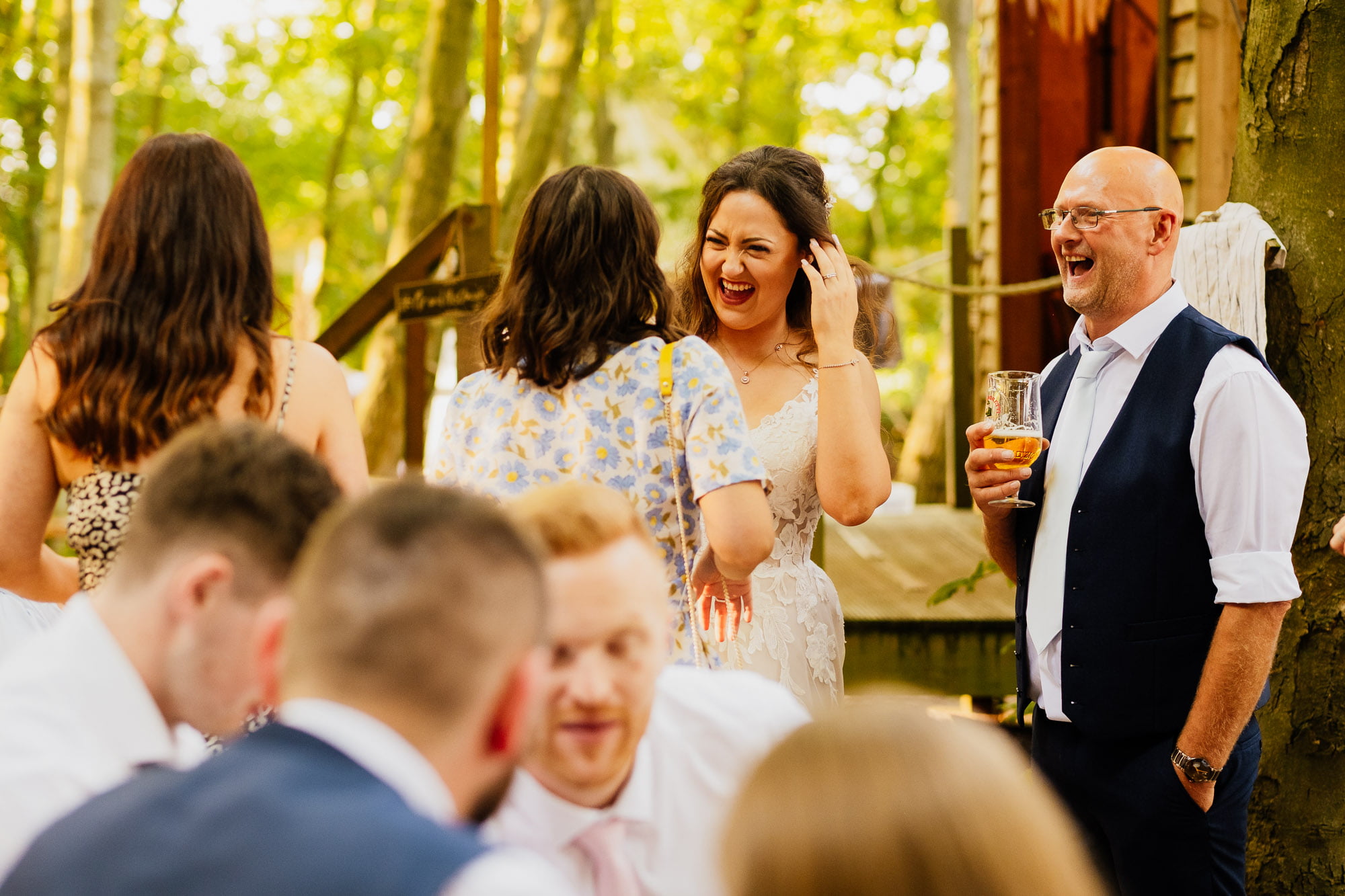 bride and guests laughing with friends at wedding