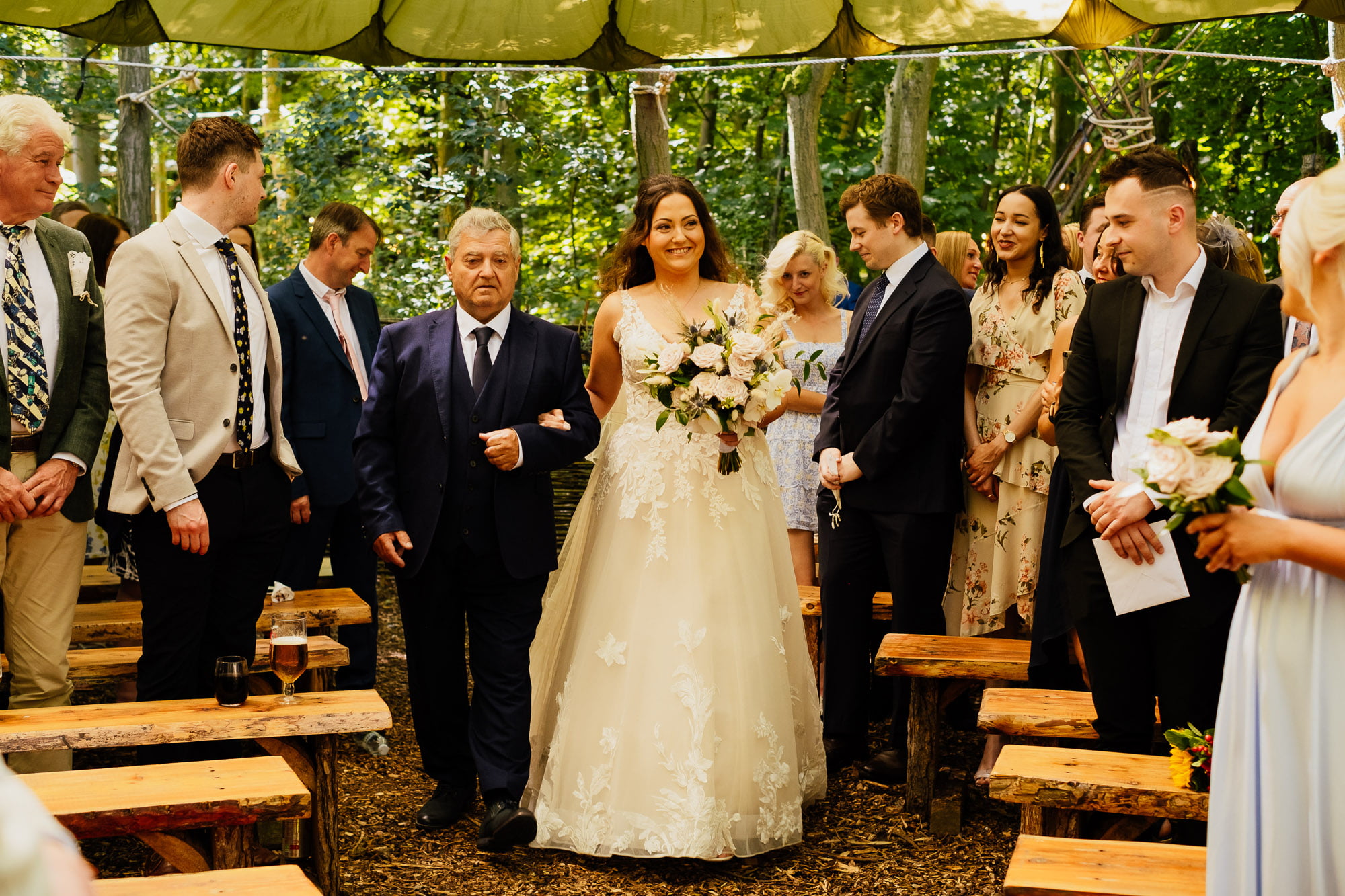 bride entrance with father walking into woodland ceremony
