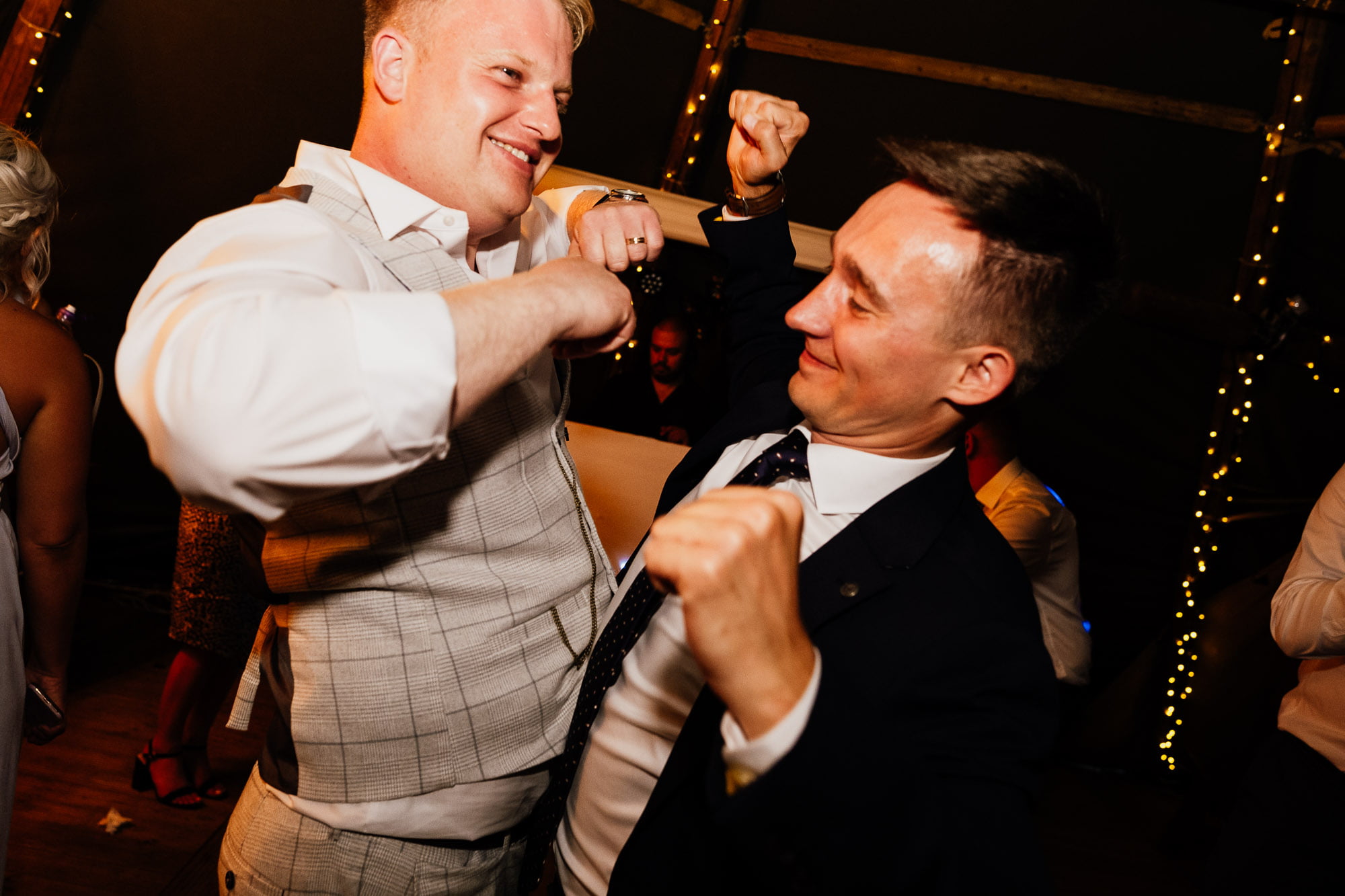 groom dancing with firend at tipi wedding