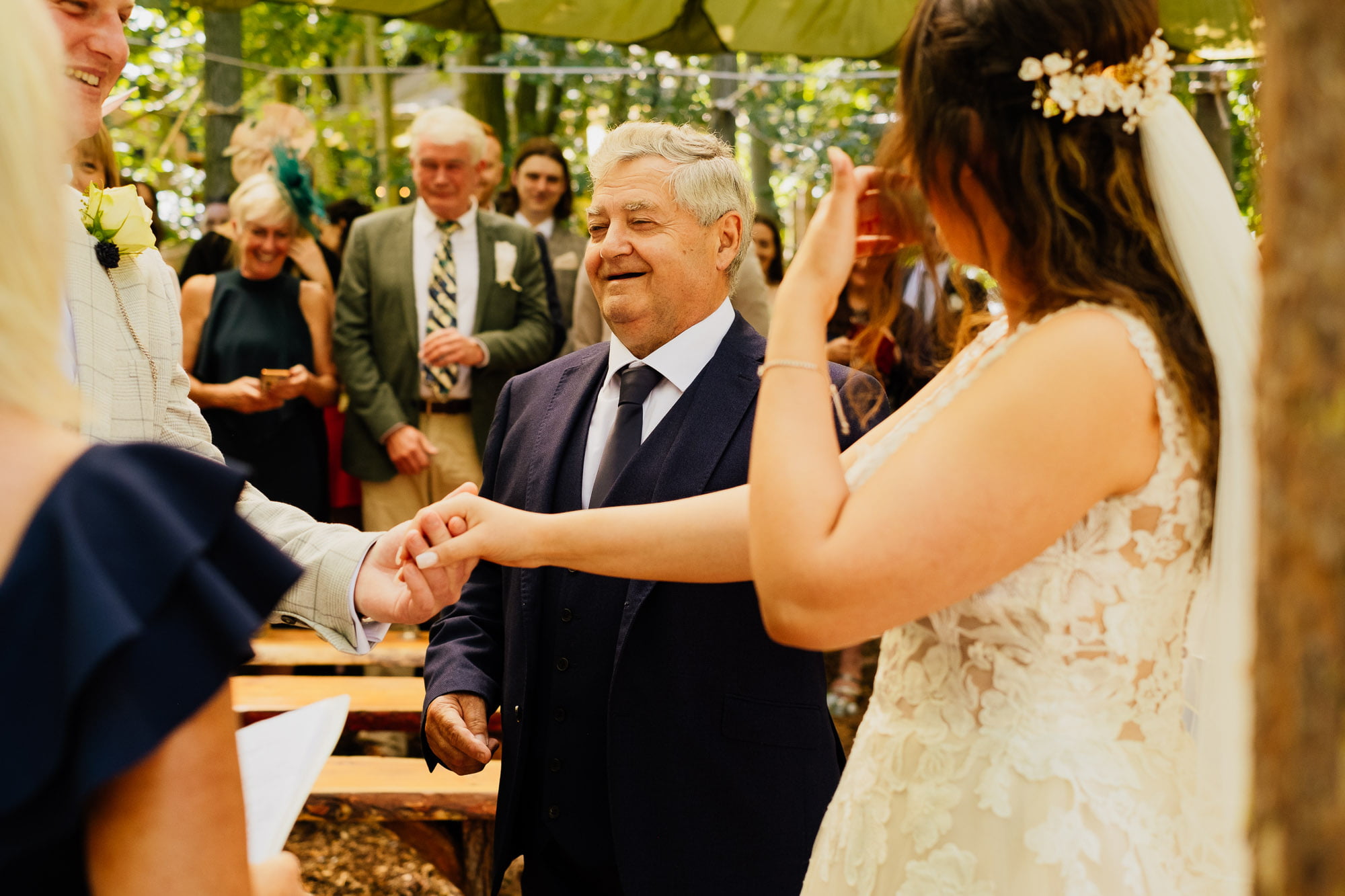 brides dad giving bride to groom during ceremony