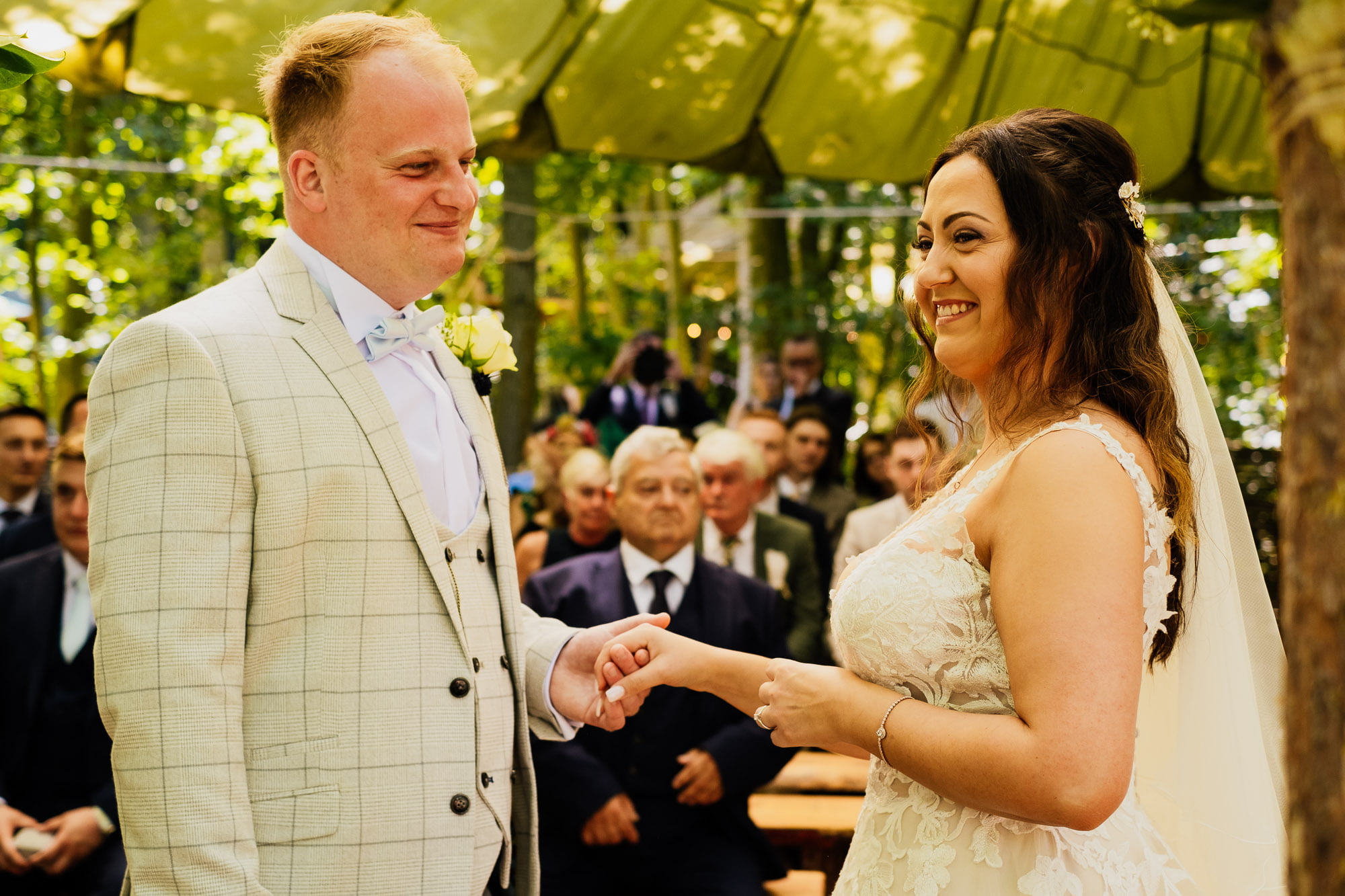 Bride holding grooms hand during outdoor cockley wood ceremony