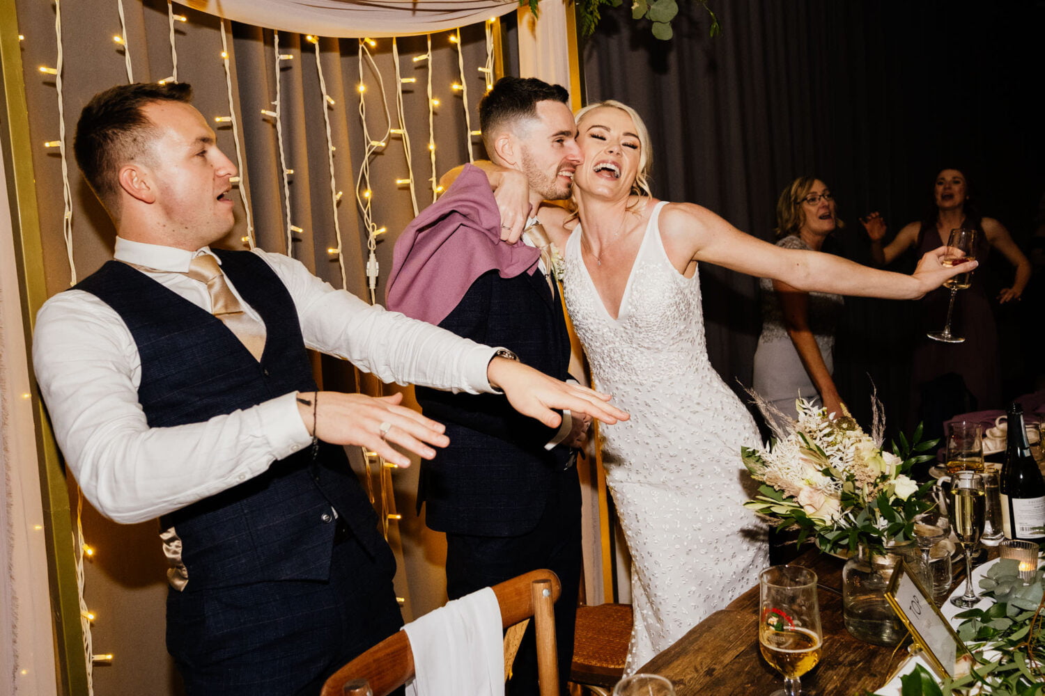 Bride singing with arm around groom during wedding entertainment