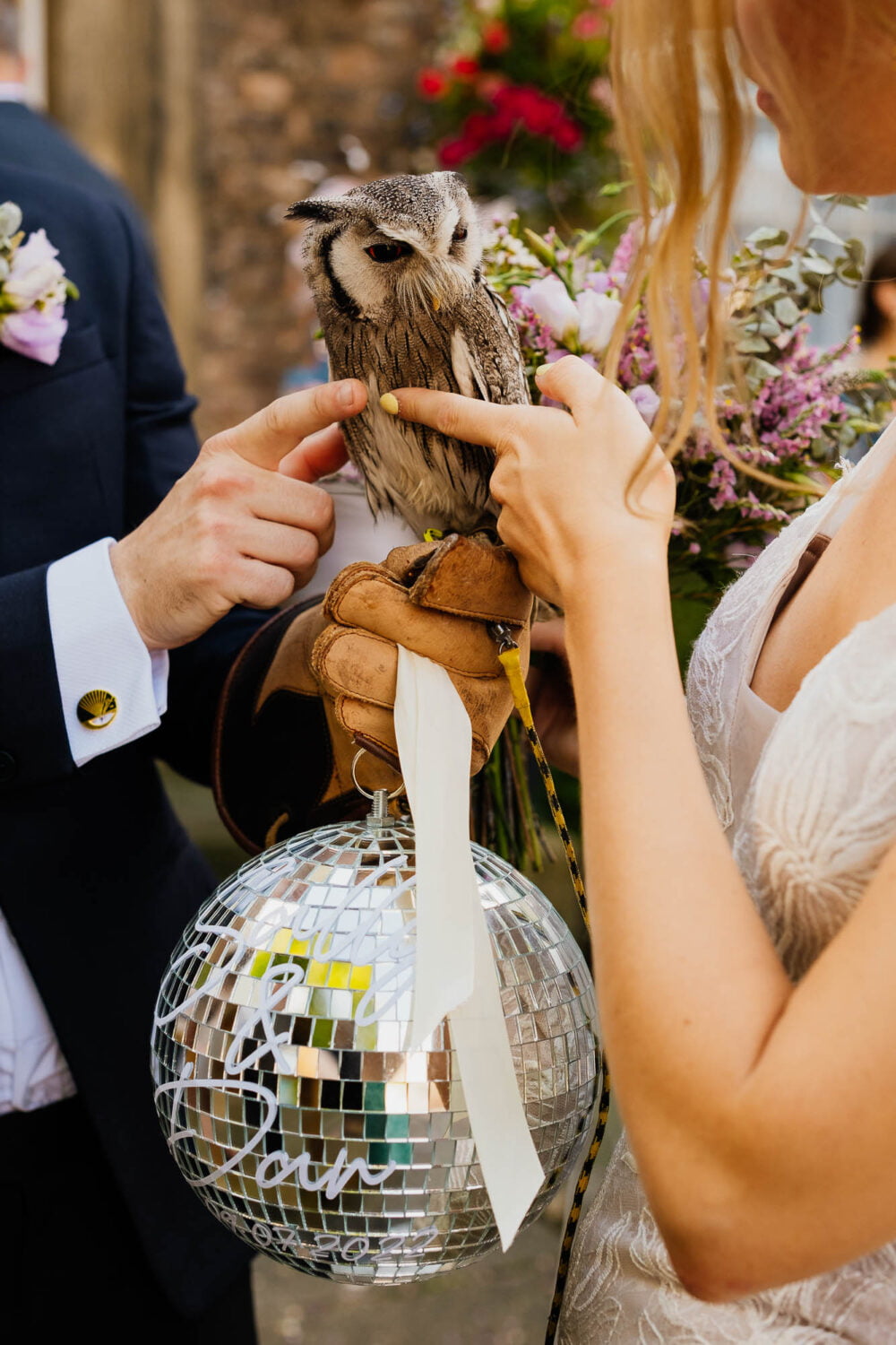 Bride and groom stroking owl and holding a disco ball