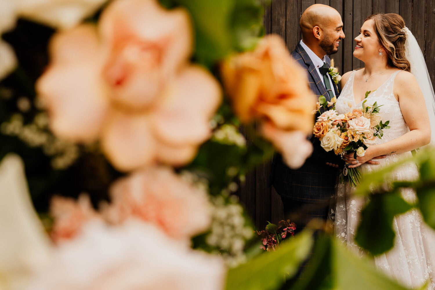 Bride and groom portrait with flowerrs in the foreground
