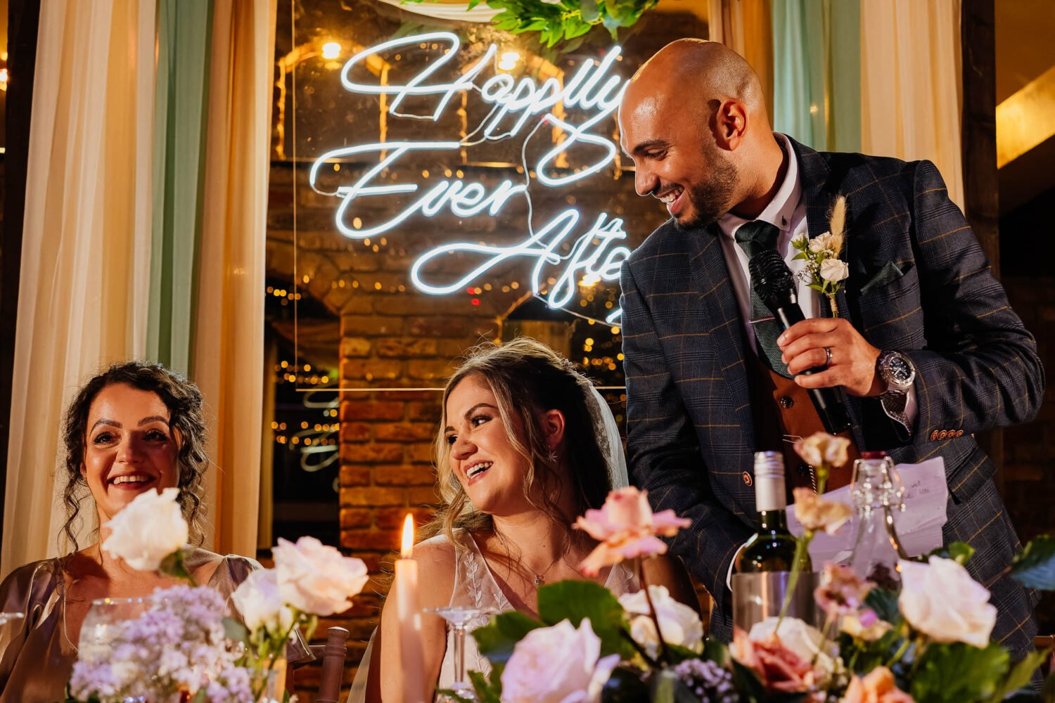 Groom and bride laughing at maid of honour during wedding speeches