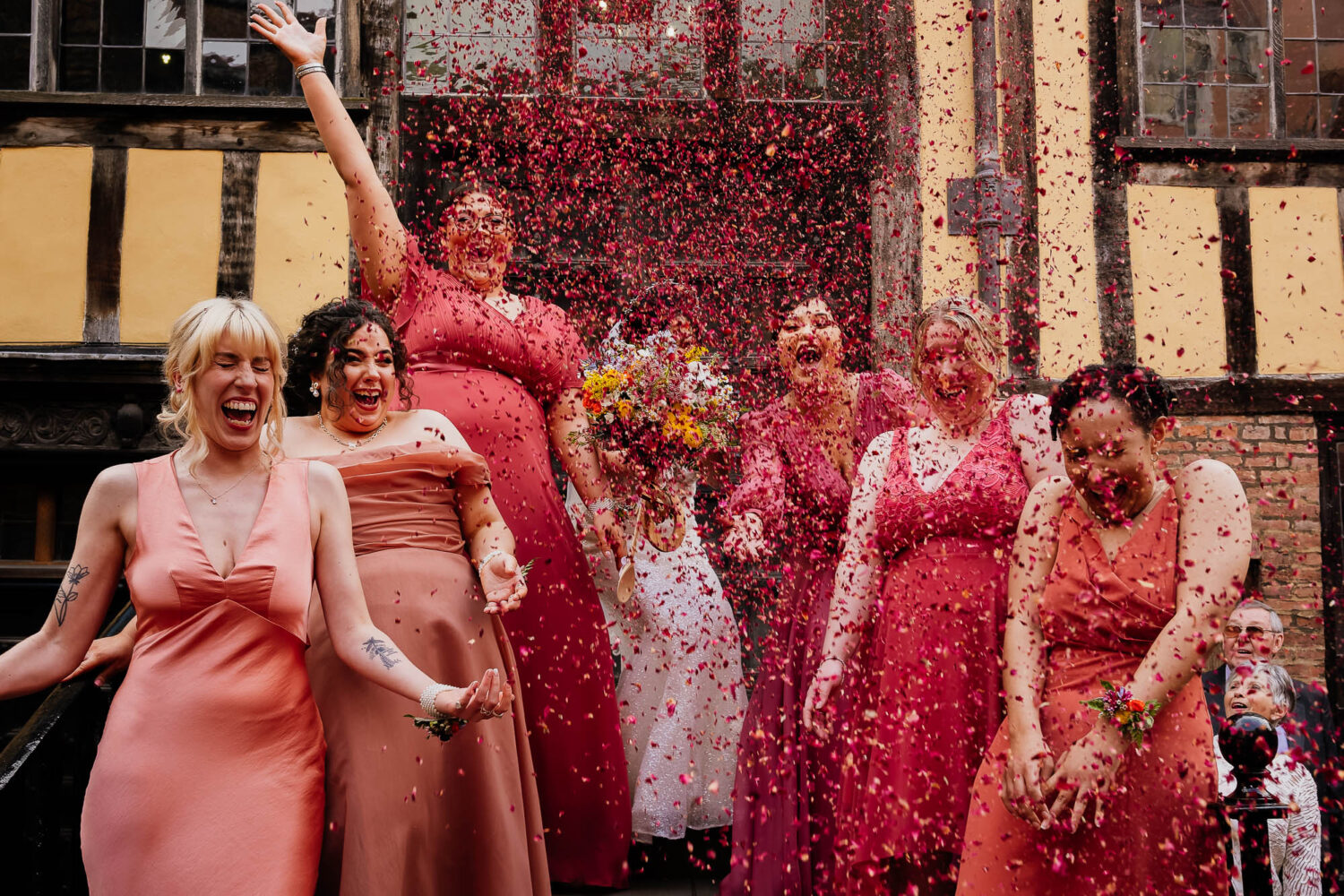 Bridesmaid group photo with pink dresses and pink confetti