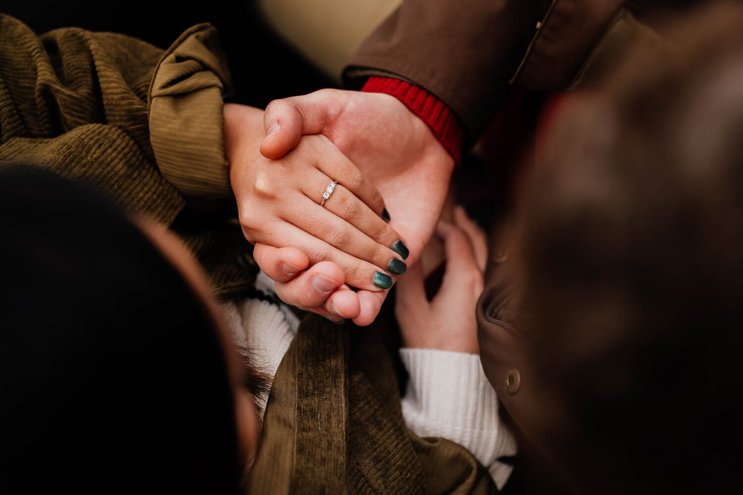 Close up of engagement ring on womans hand being held
