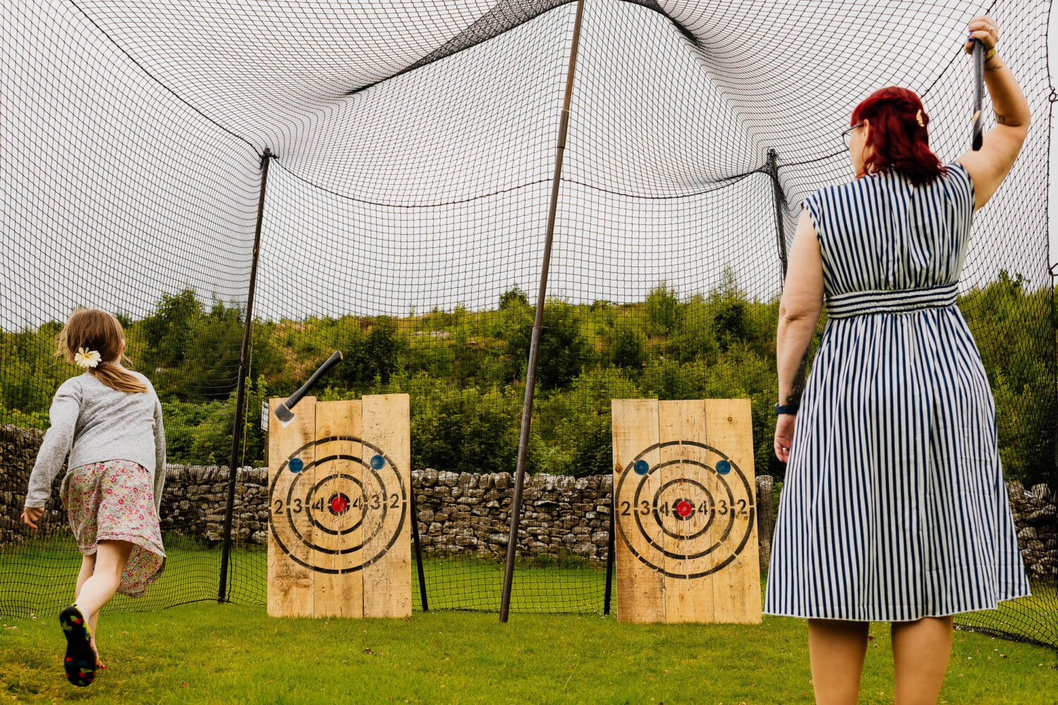 An adult and child axe throwing at a wedding