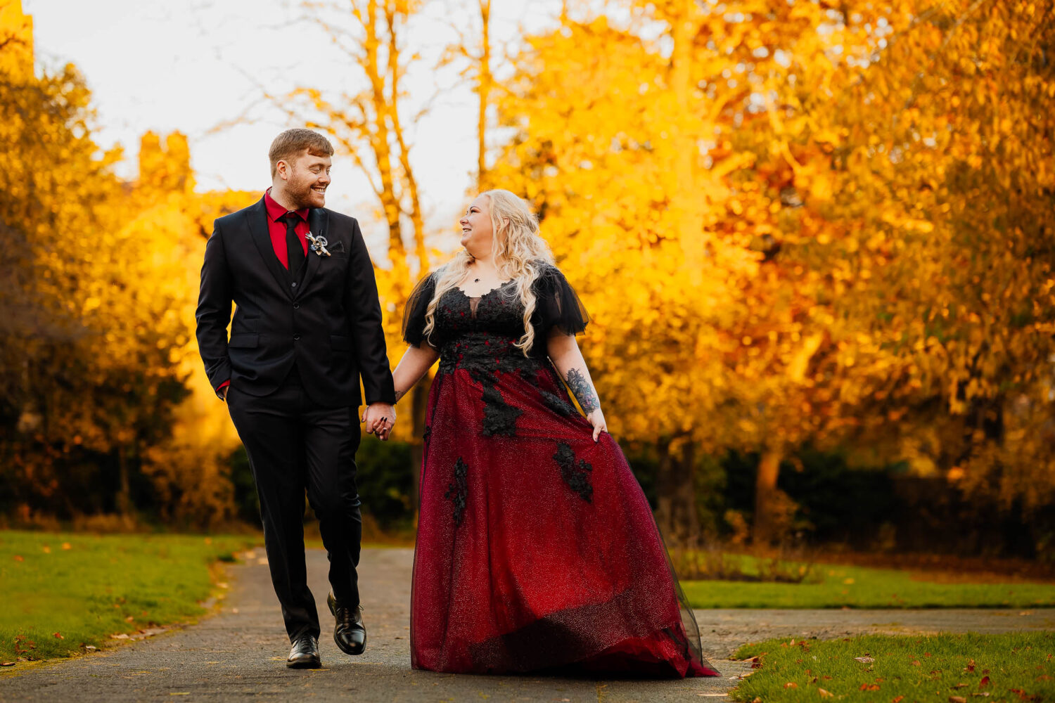 Golden hour wedding portrait at sunset in a park with couple holding hands