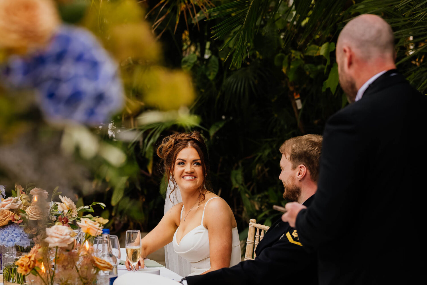 Bride smiling during wedding speeches at the Palm House