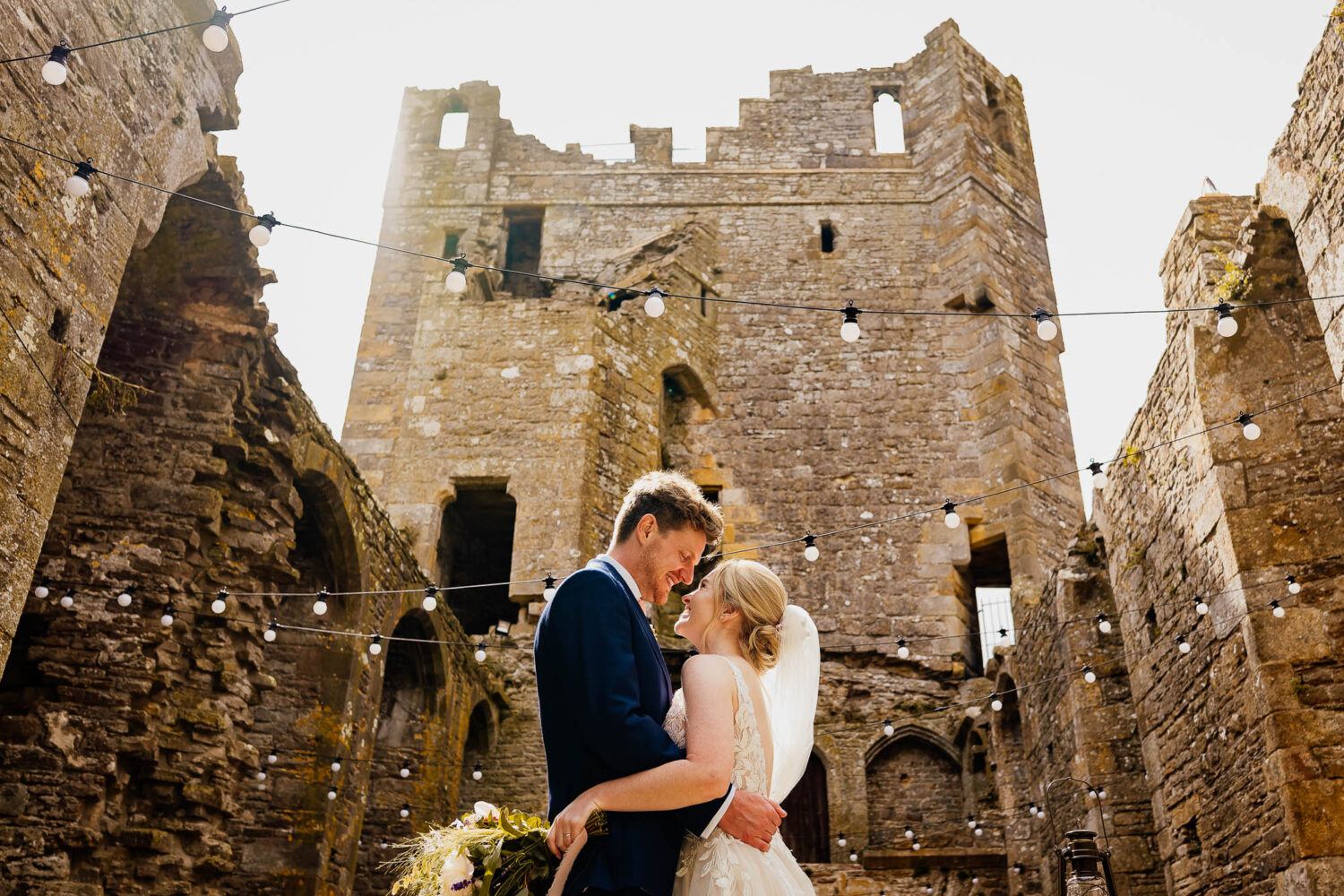 Couple hugging in the Chapel at Bolton Castle, backlit by the sun