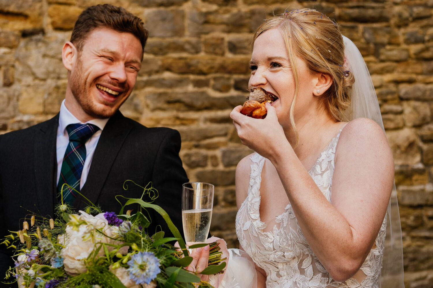 Bride eating a canape during the drinks reception at Bolton Castle