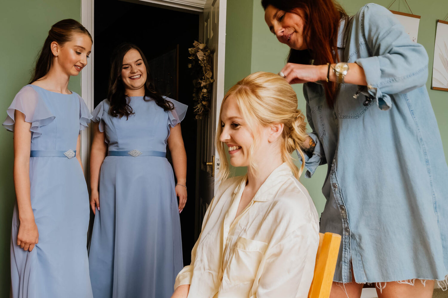 Bridemaids watching bride have her hair done