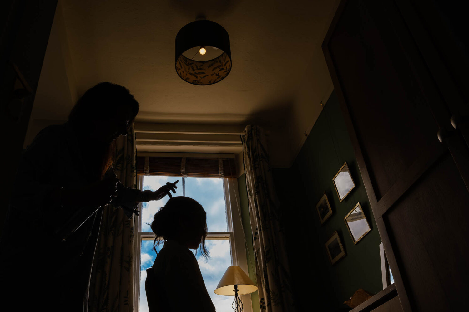 Bride silhouette in the window whilst getting her hair done