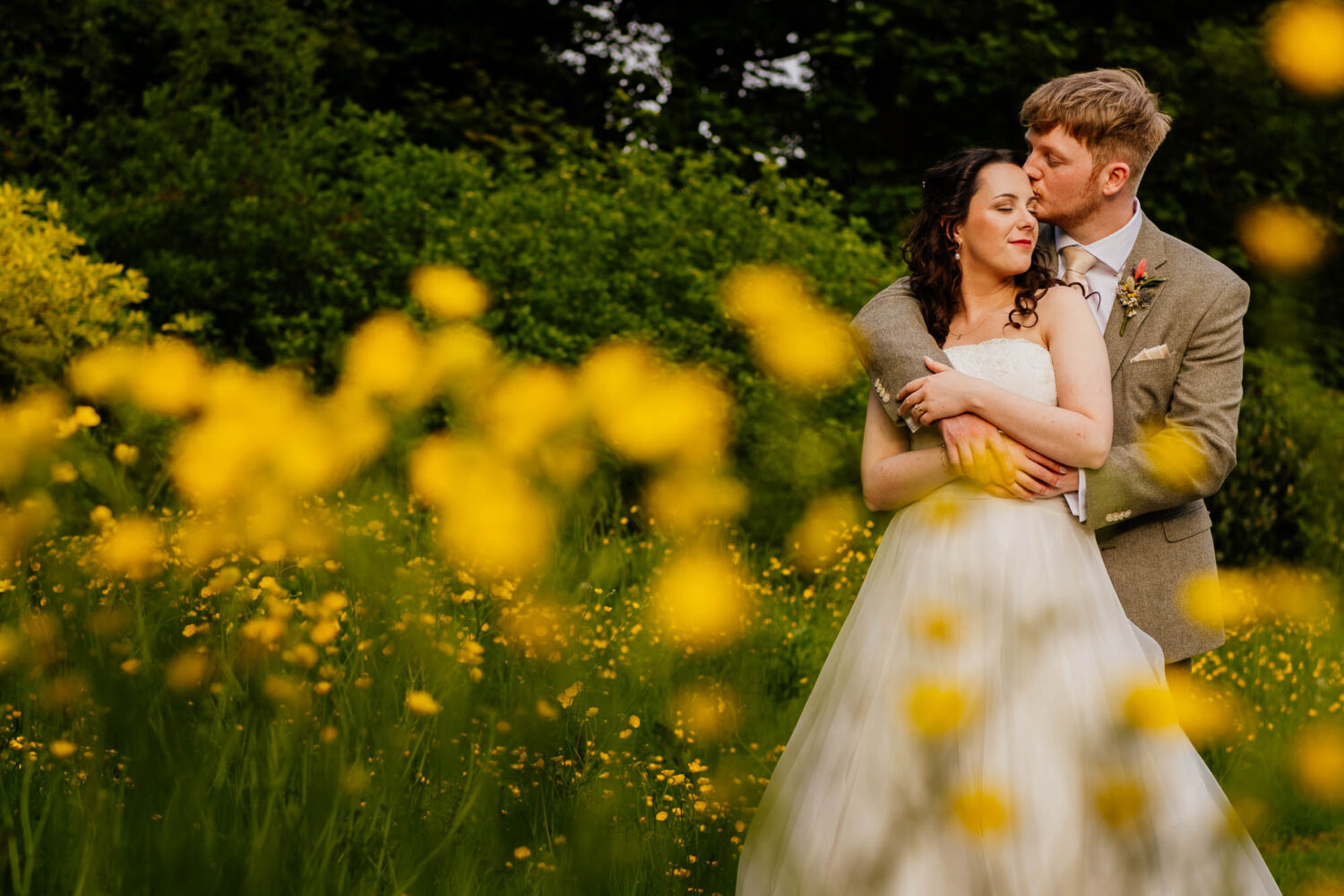 Couple embracing with yellow flowers in the foreground