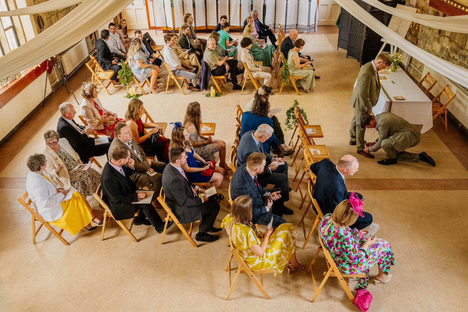 Best man tying grooms shoes whilst waiting for the ceremony to start