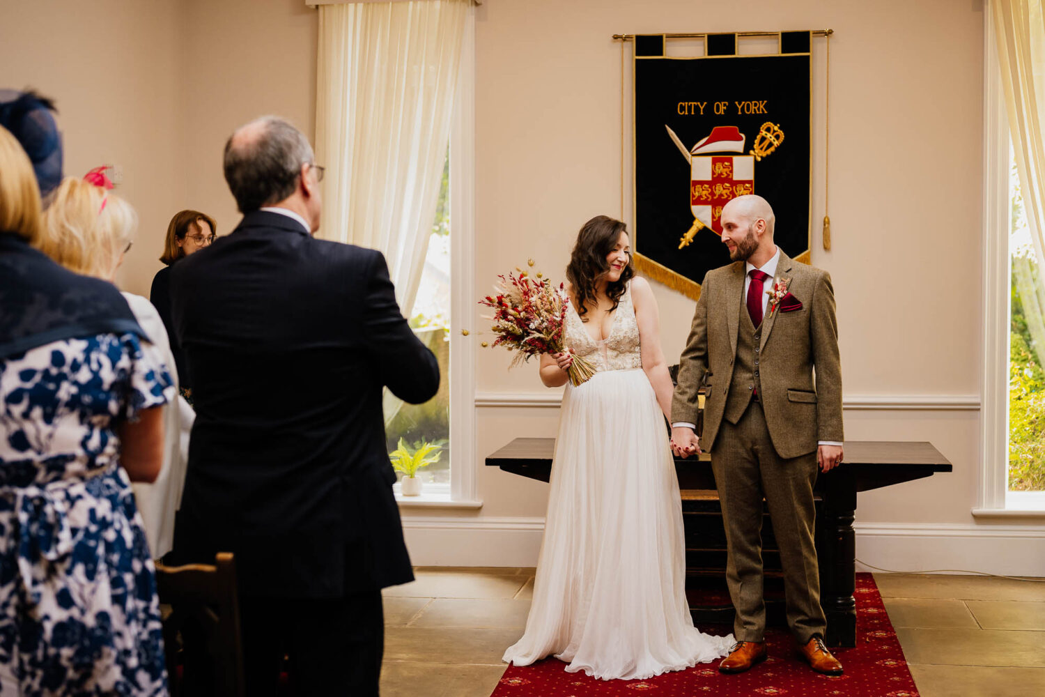 Bride and groom holding hands at York register office
