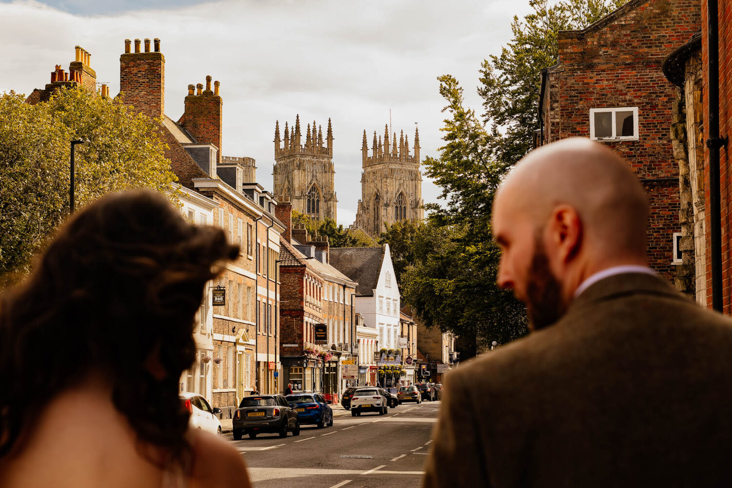 Bride and groom walking down the street with York Minster in the background