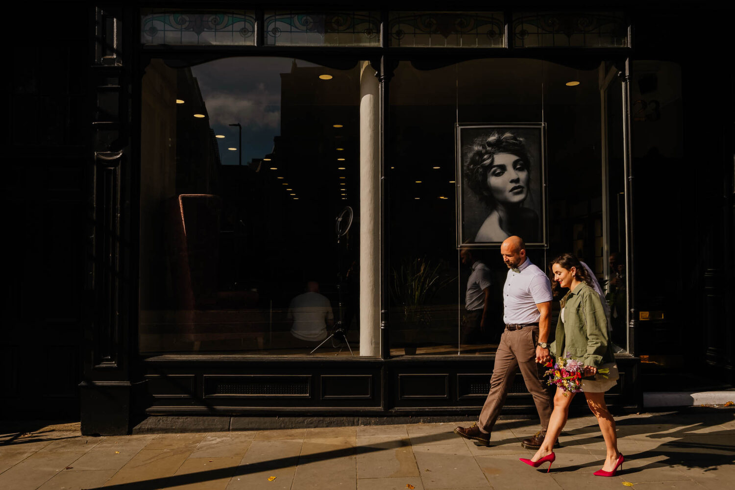 Couple walking along city street in the sun
