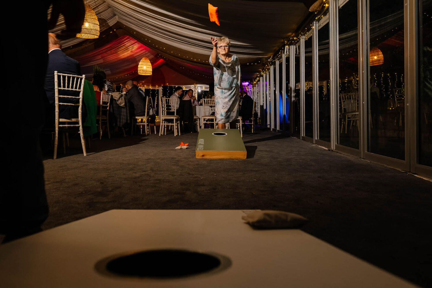 Grandma playing cornhole in the evening