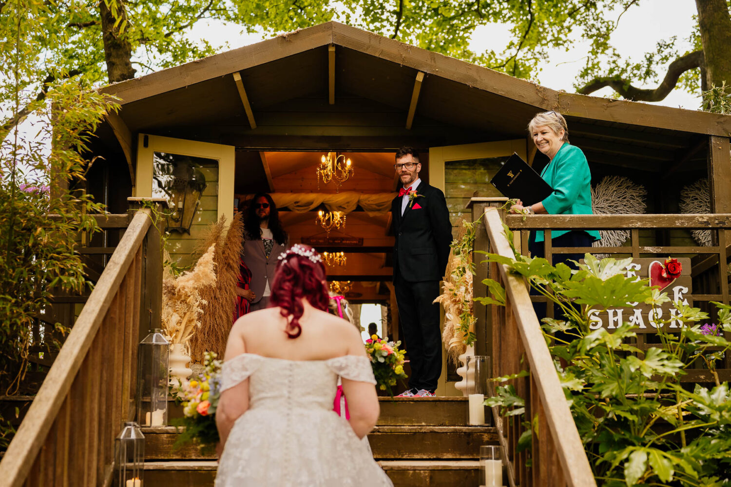 Bride walking up the steps to The Love Shack with groom waiting