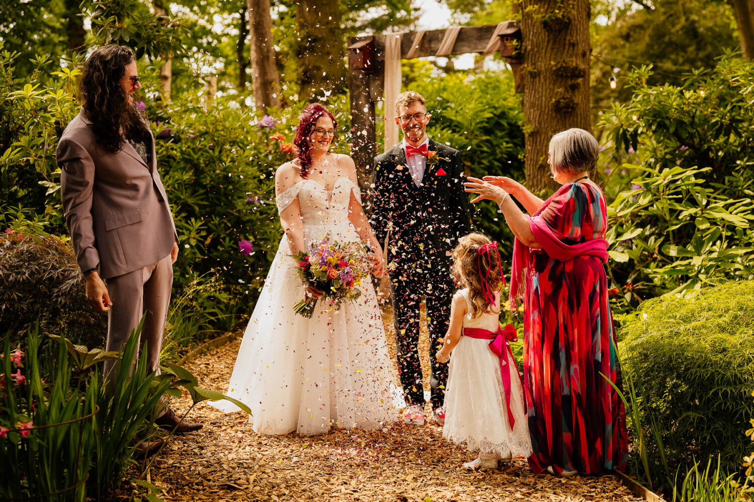 Guests throwing confetti on the woodland path at The Love Shack