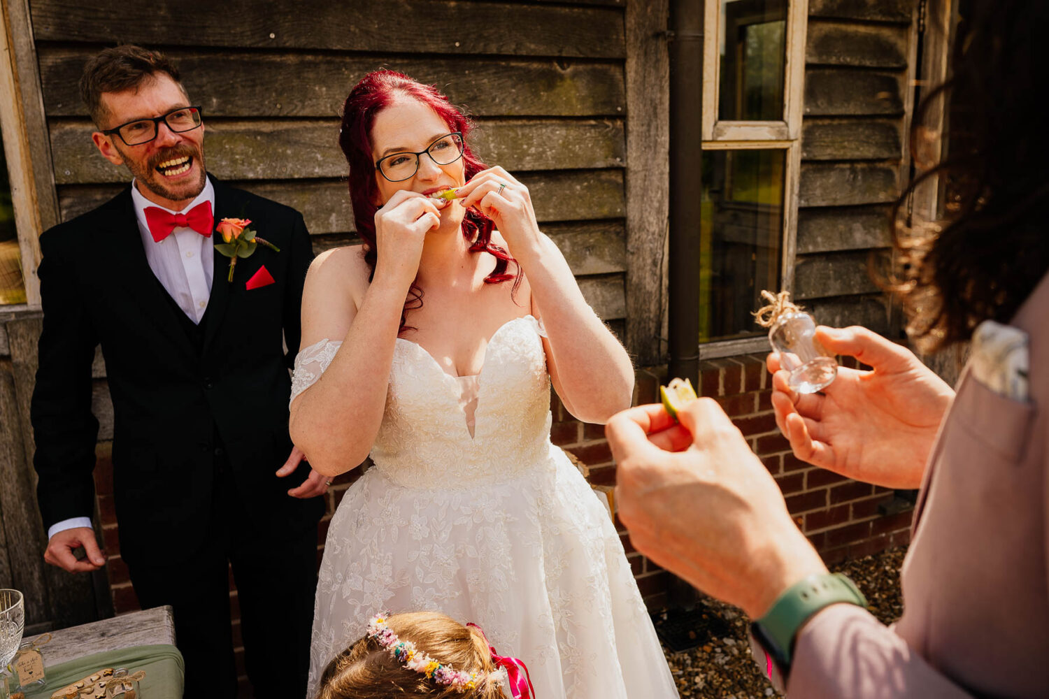 Bride biting lime after tequila shot