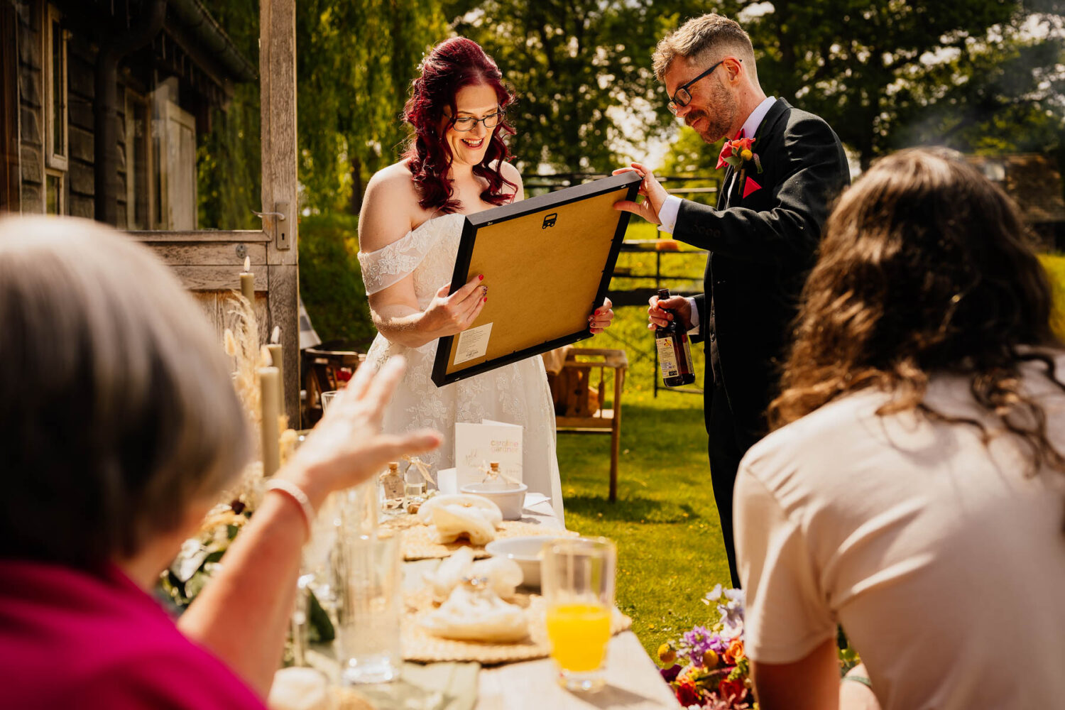Bride looking at wedding gift with groom