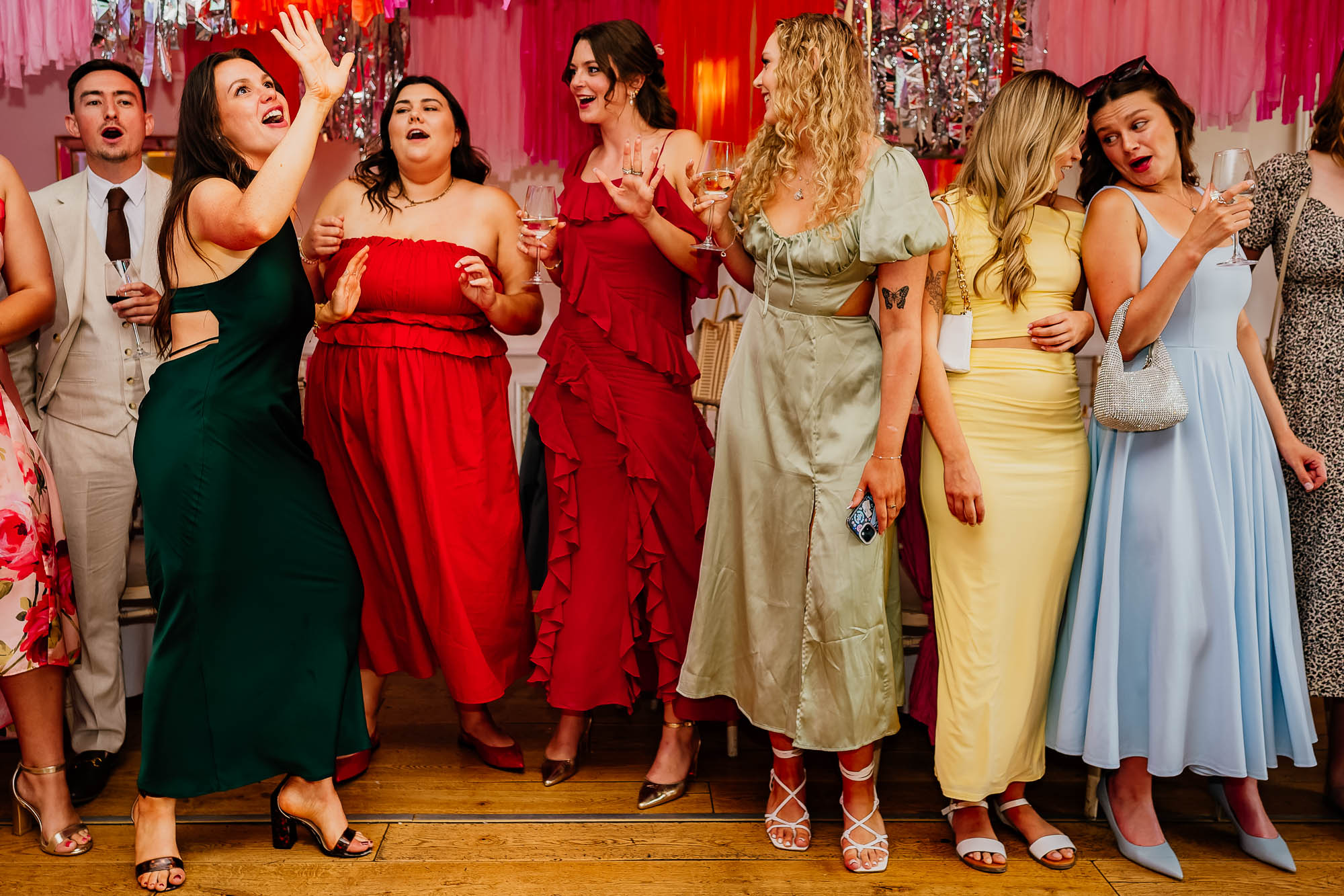 Wedding guests in a line on the dancefloor singing