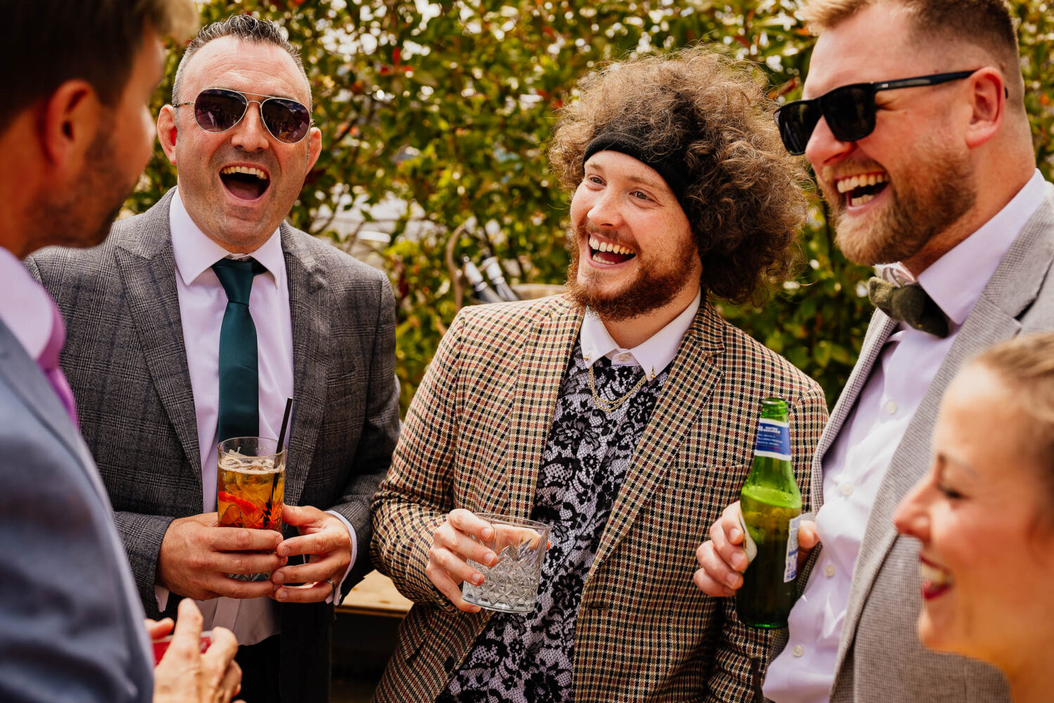 Three guests holding drinks and laughing
