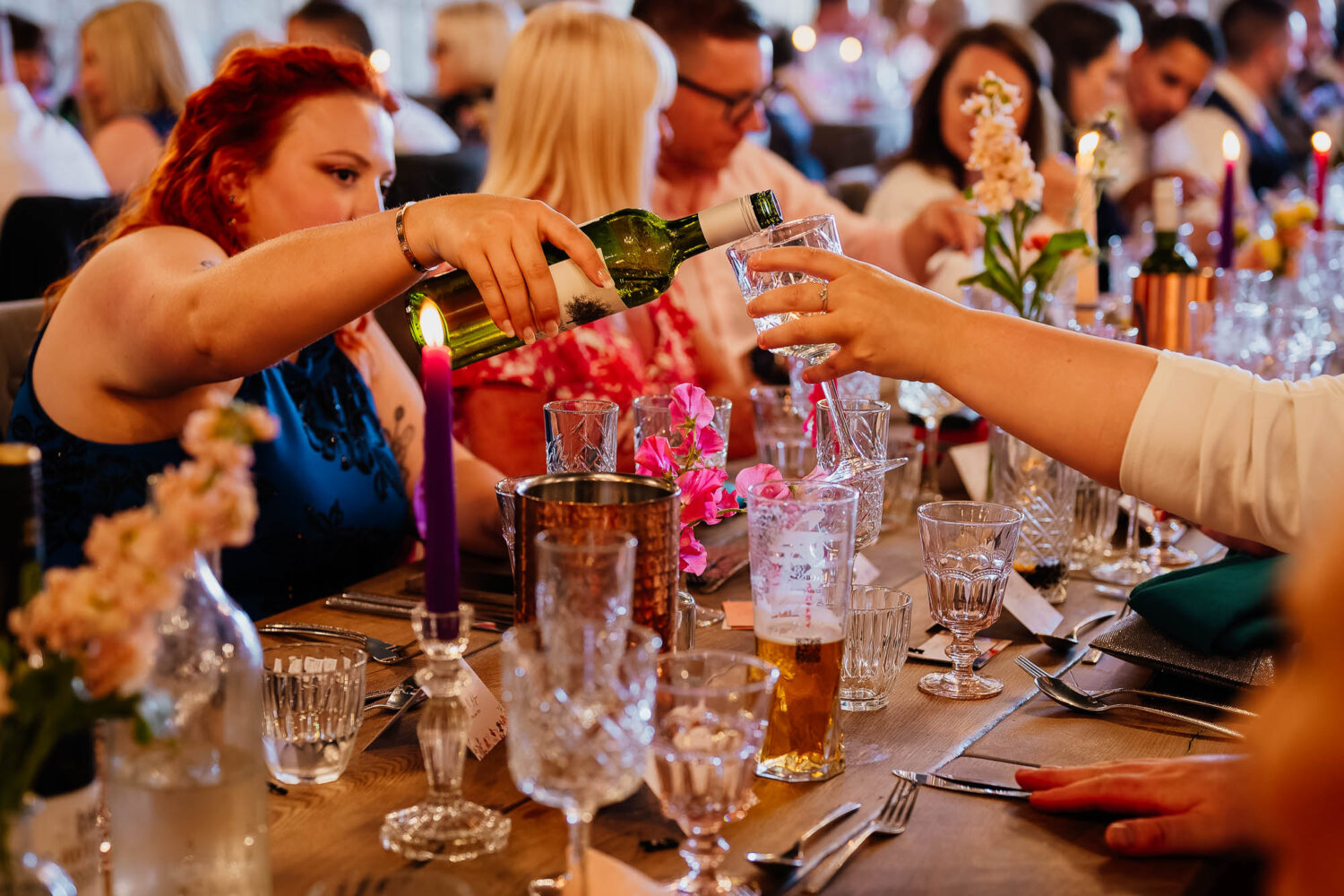 Wedding guests pouring drink at Wharfedale Grange wedding breakfast