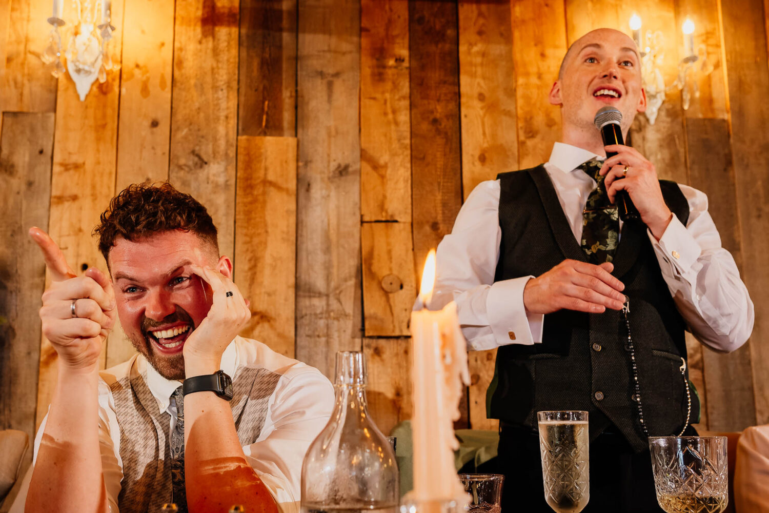 Groom laughing and pointing during wedding speeches at Wharfedale Grange