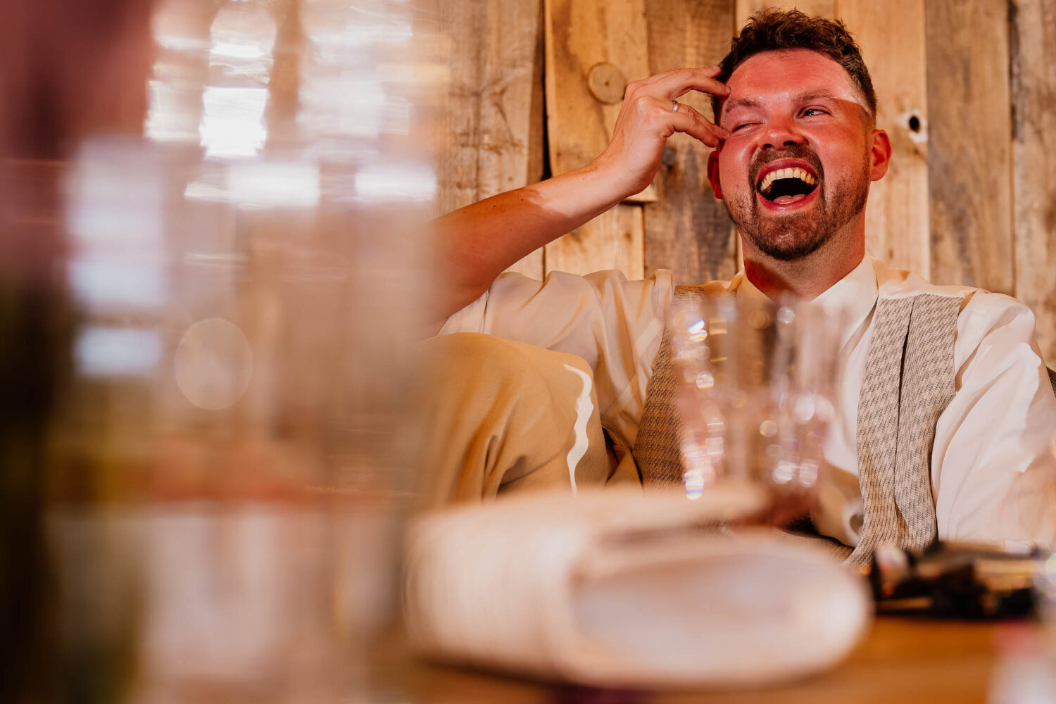 Groom wiping tears from his eyes during wedding speeches