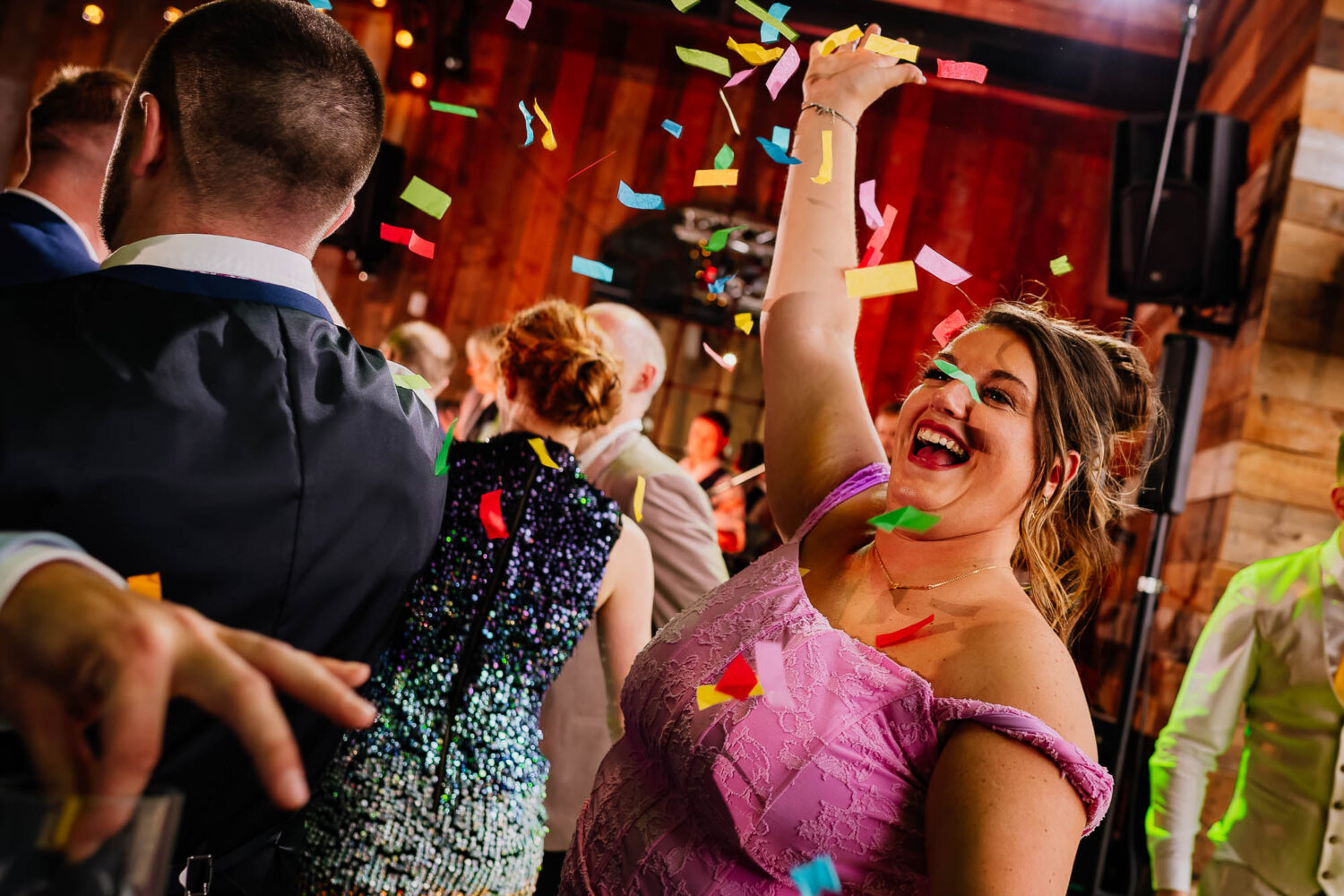 Woman throwing confetti up in the air on the dancefloor