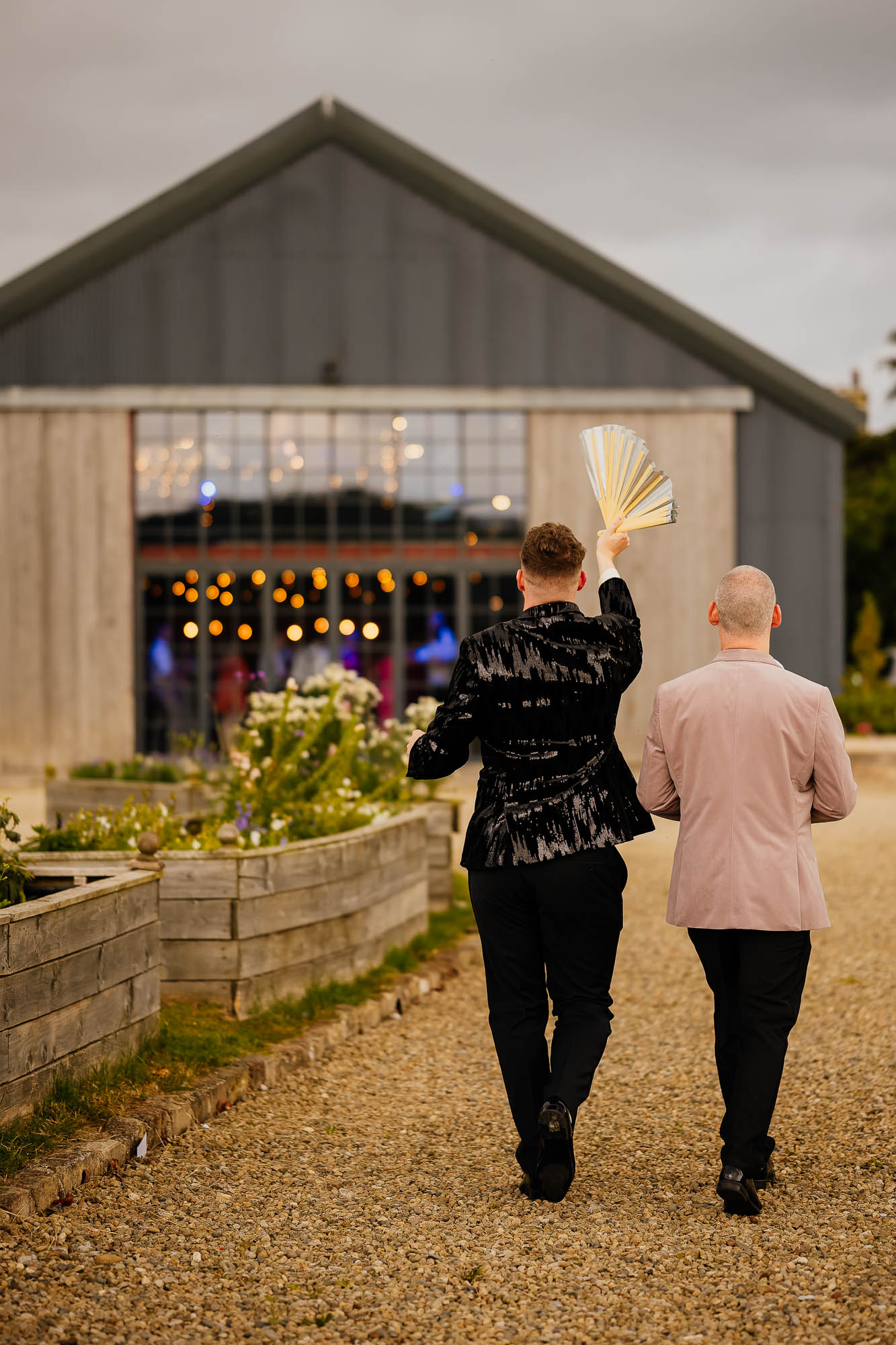 Grooms walking towards Wharfedale Grange with DJ lights in the background