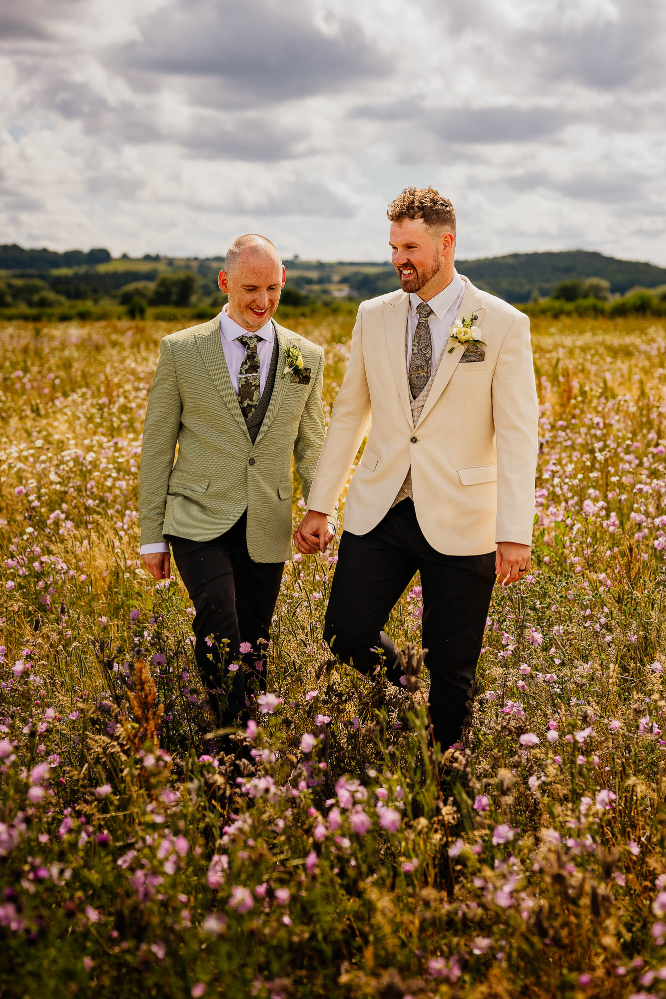 Gay couple walking through meadow at Wharfedale Grange