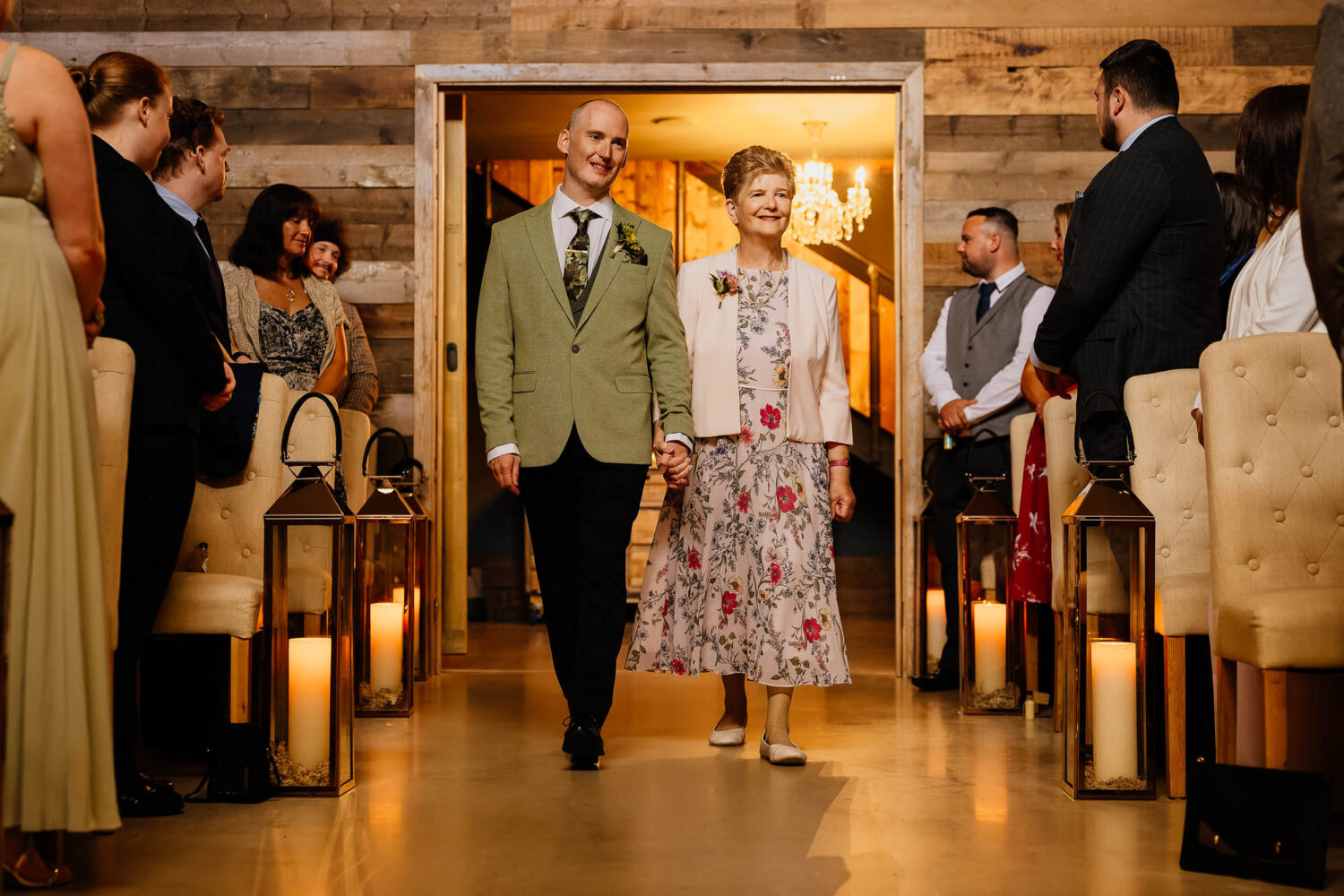 Groom walking down aisle with mum