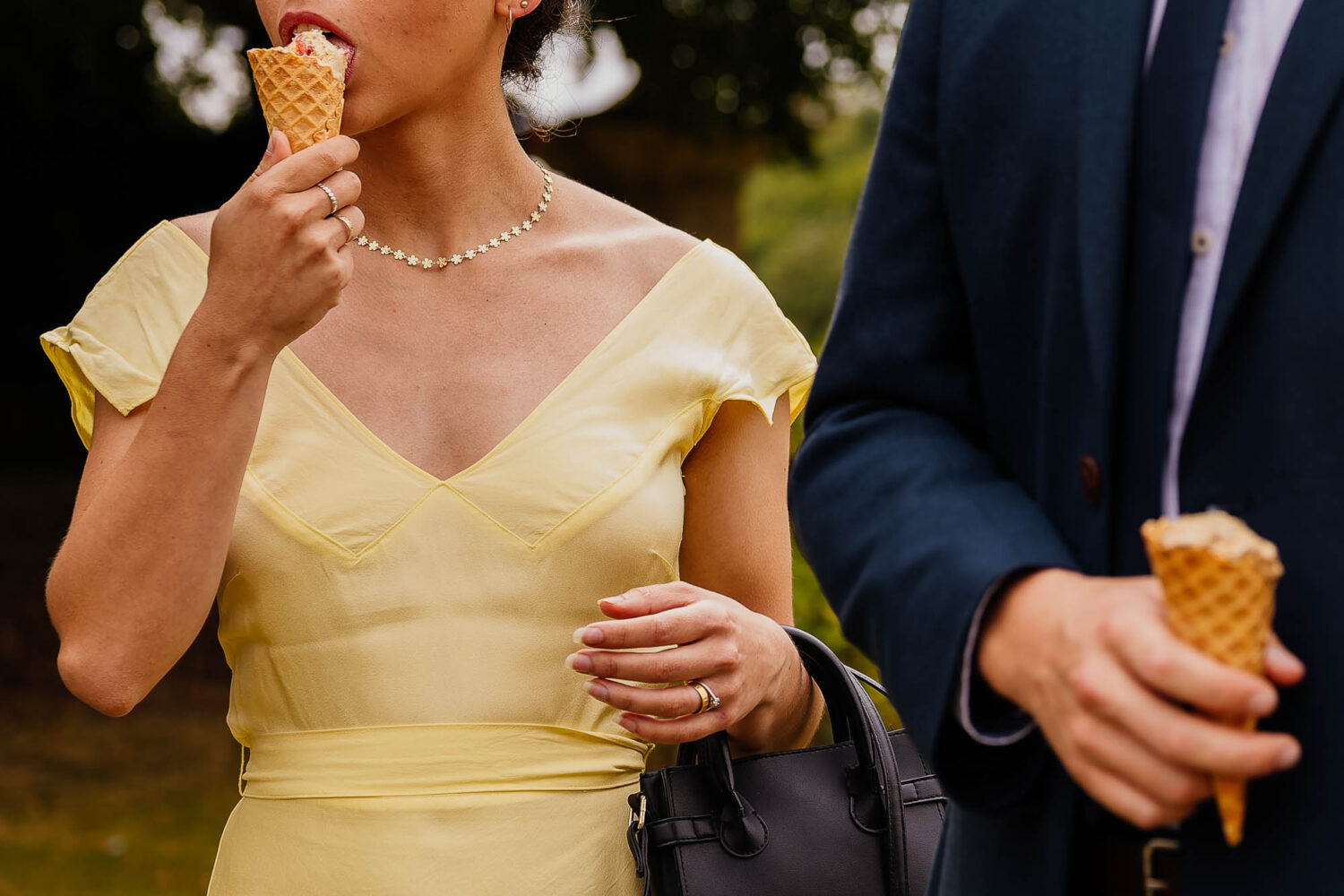 Woman in yellow dress eating icecream with man holding icecream next to her