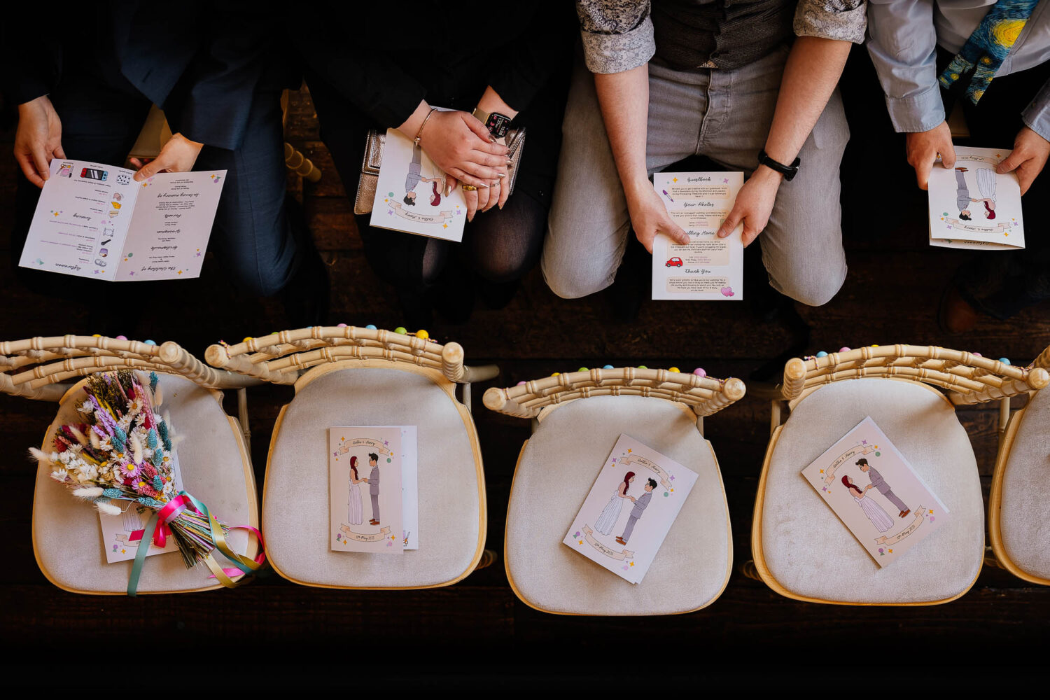 Guests holding wedding order of services from above
